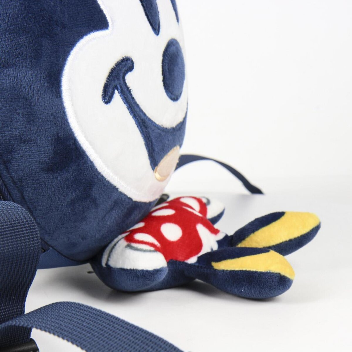 Primer plano de una mochila azul de Mickey Mouse con un diseño de lunares rojos y blancos en la parte inferior.