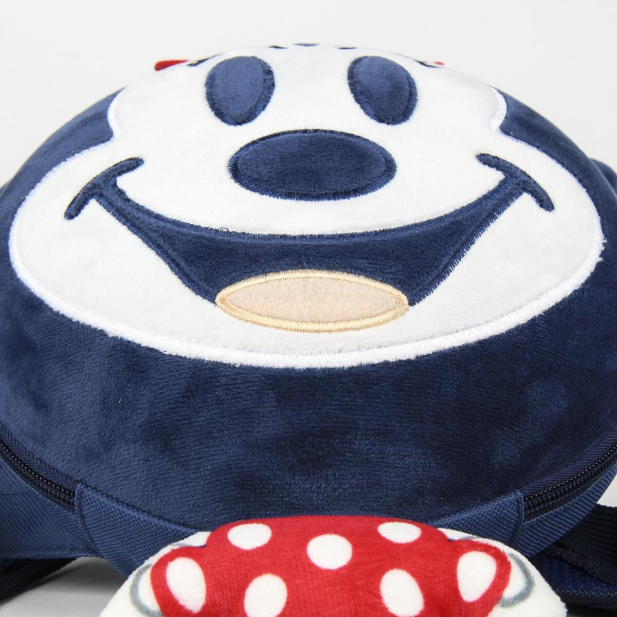 Primer plano de una bolsa azul de Mickey Mouse con una cara sonriente, un diseño de puntos rojos en la parte inferior.
