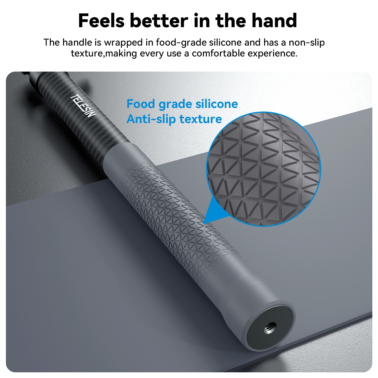 Close-up van een grijze selfiestick handgreep met een getextureerde grip, blauwe achtergrond.