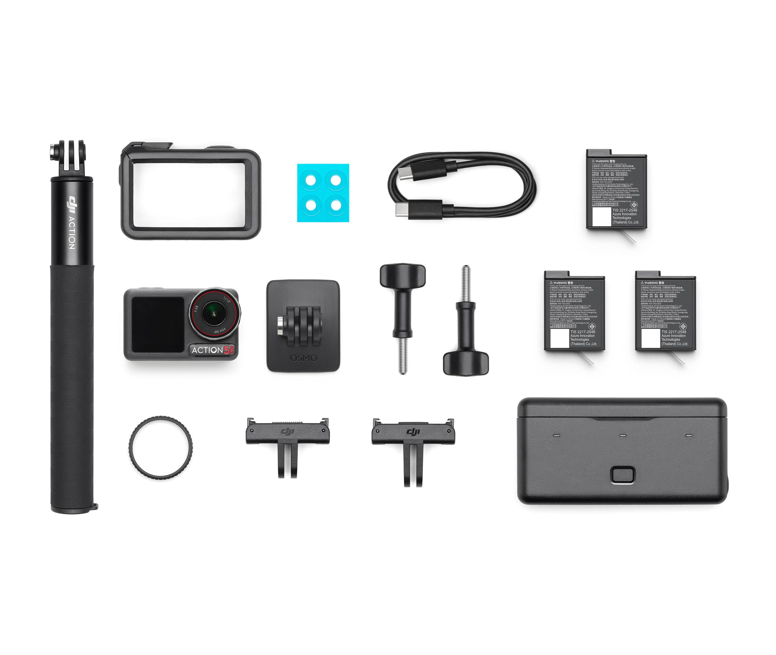 Accessori per fotocamere, tra cui una fotocamera, batterie e cavi. Sfondo bianco.