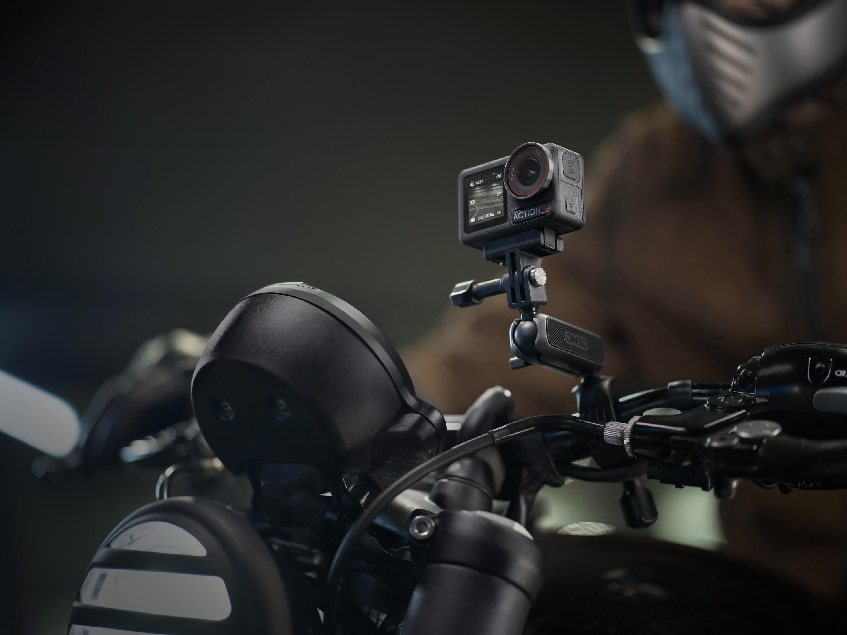 Action cam montata sul manubrio di una moto. Una persona sullo sfondo.