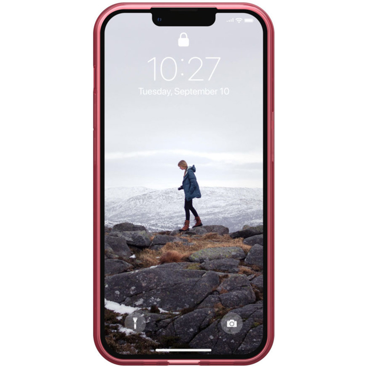 Ein Telefon in einer rosa Hülle zeigt eine Person, die auf Felsen geht, mit Bergen im Hintergrund.