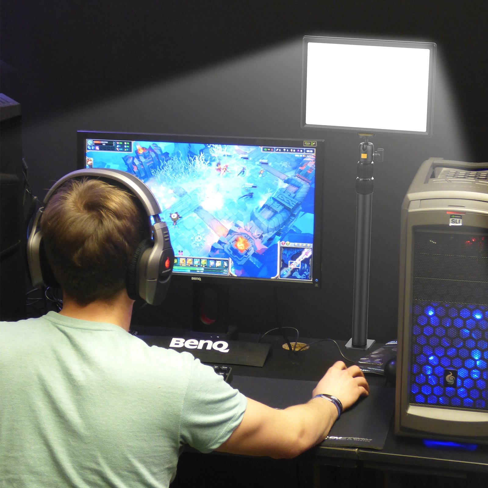 Ein Mann mit Kopfhörern spielt ein Spiel am Computer. Das Licht ist weiß.