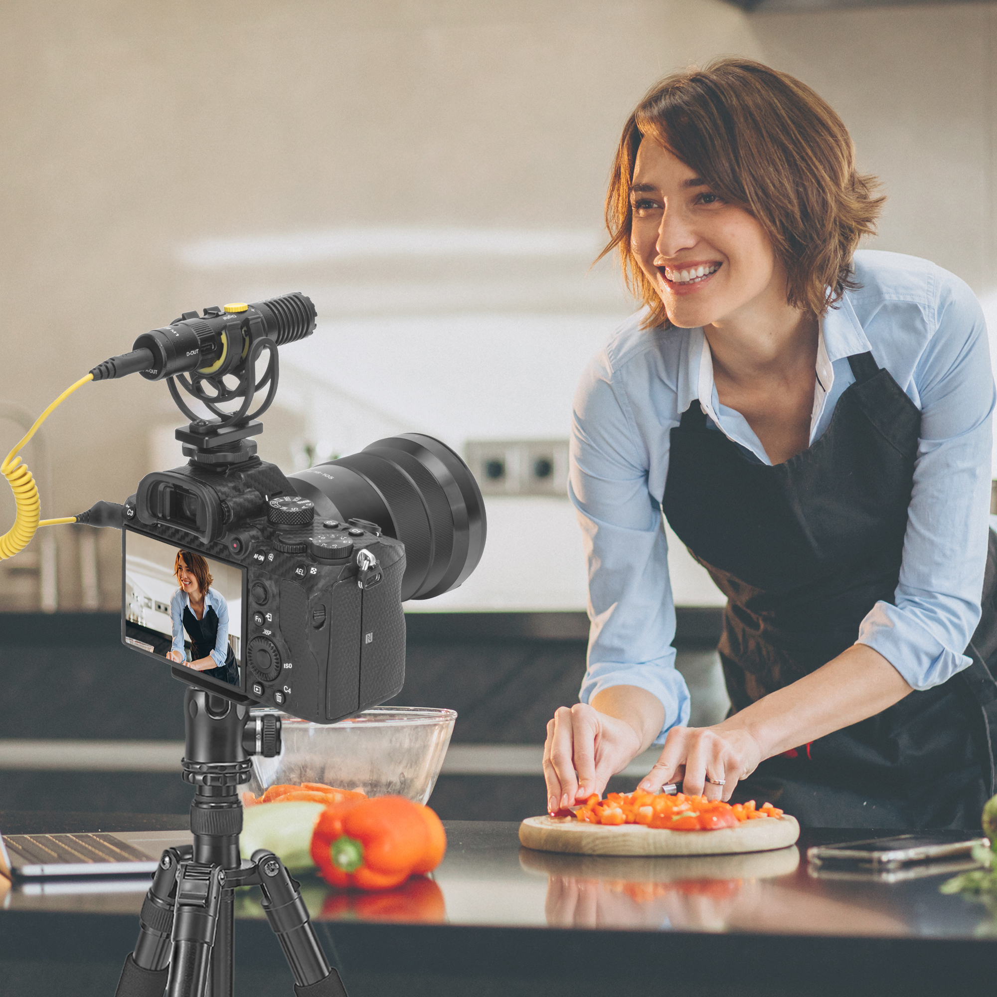 Woman vlogging, filming herself cutting vegetables. Camera on tripod with microphone, kitchen scene with food on counter.