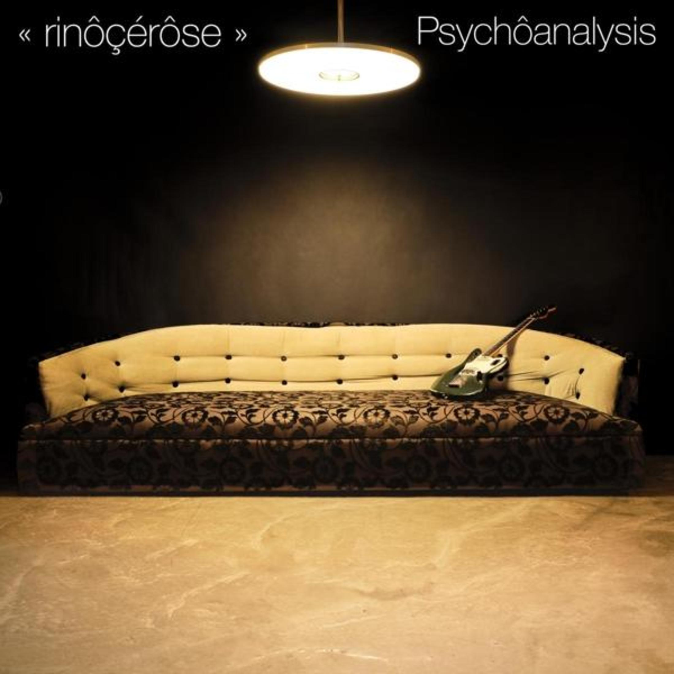 Copertina dell'album con un divano e una chitarra sotto una luce intensa, sfondo scuro.