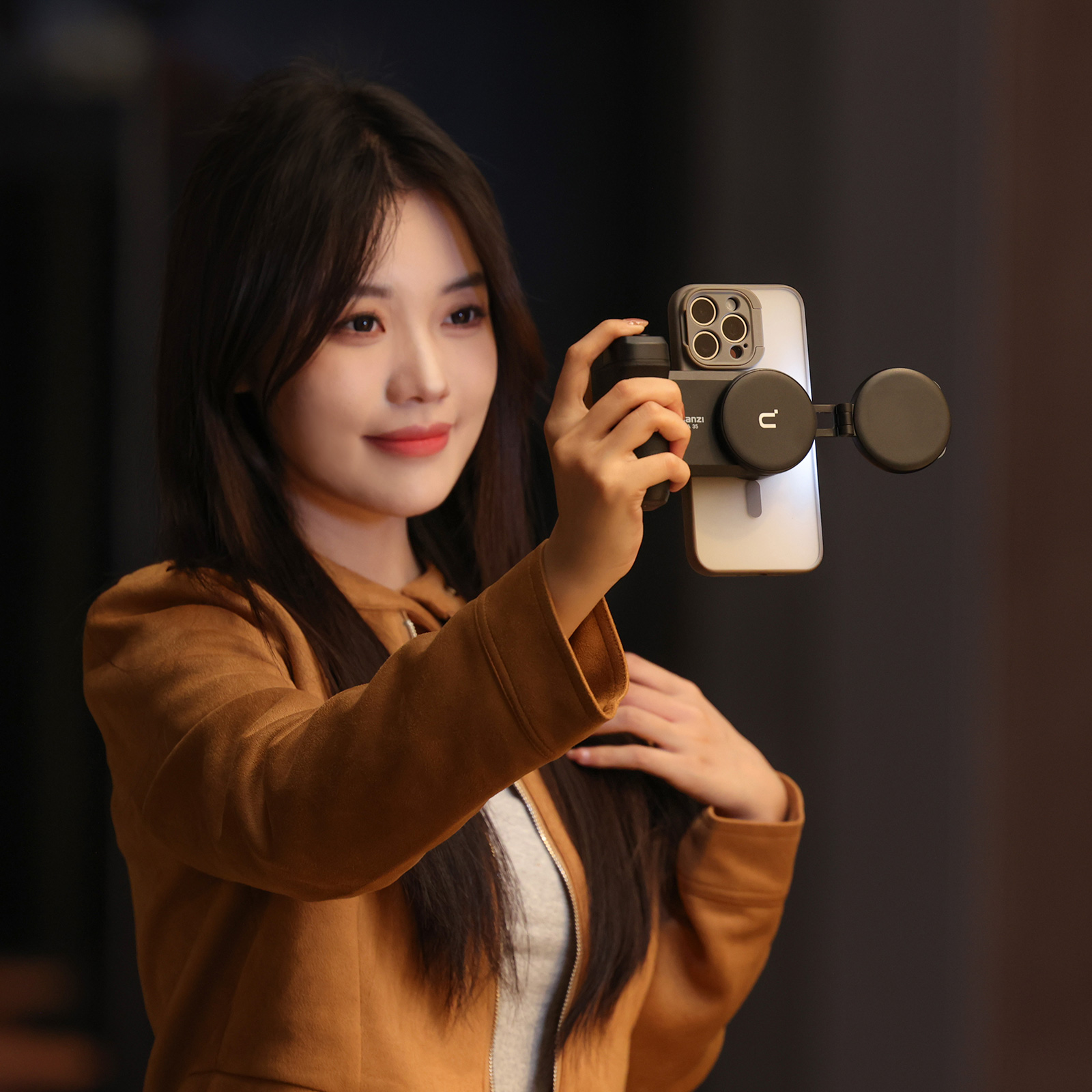 Kobieta trzyma telefon przymocowany do uchwytu z lampą pierścieniową, robiąc selfie.
