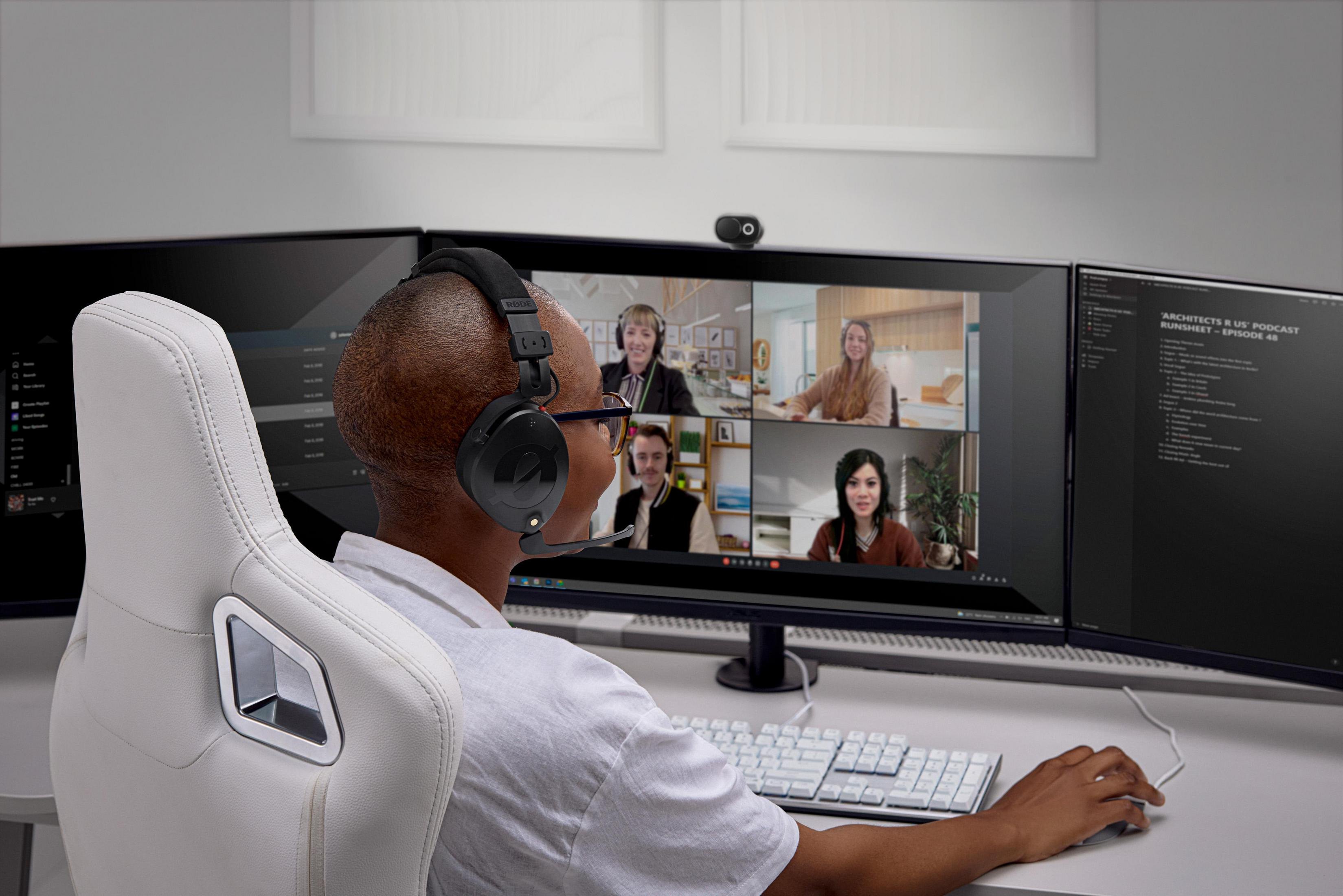 Mężczyzna w słuchawkach przed ekranem komputera z trwającą rozmową wideo.