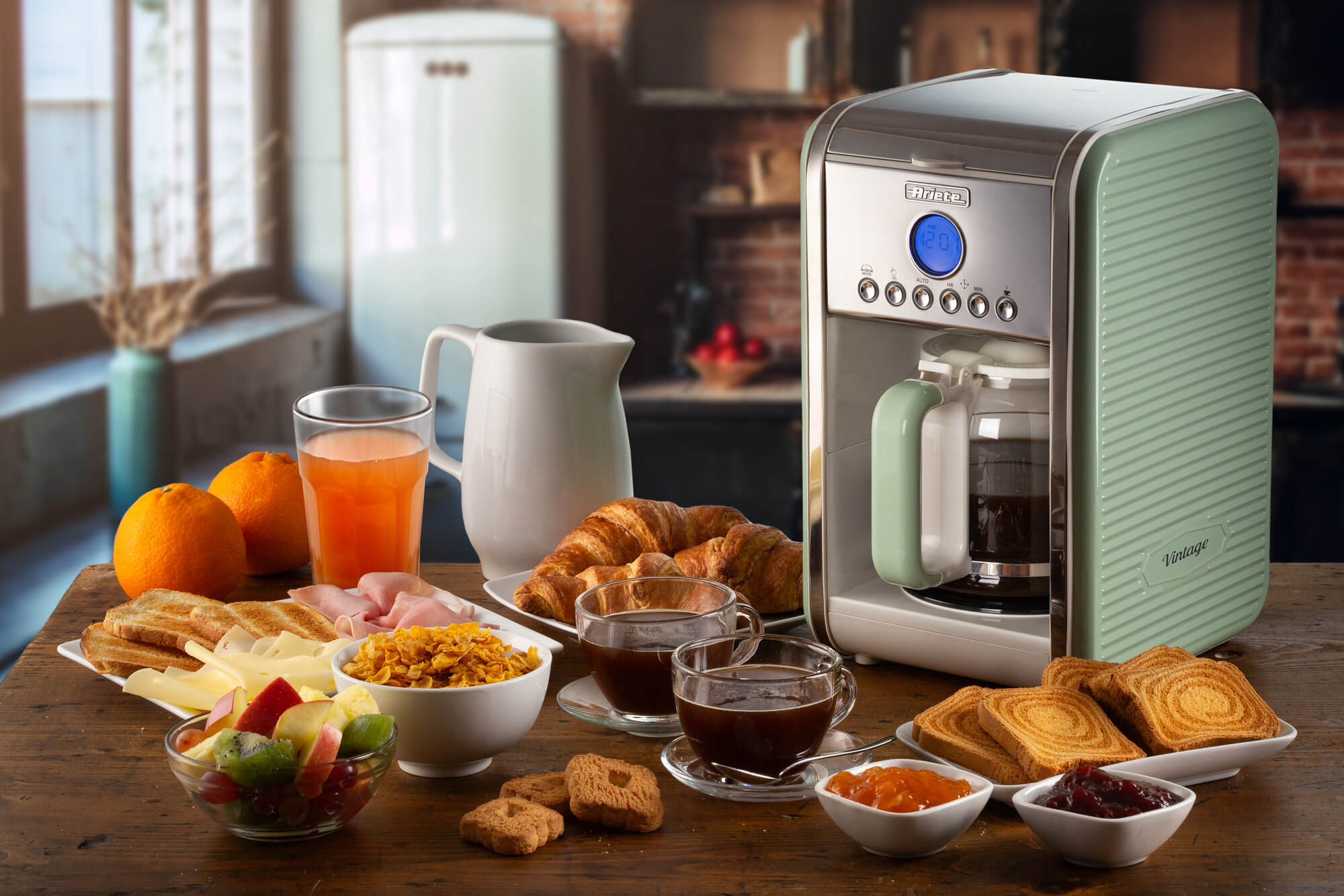 Stół śniadaniowy z ekspresem do kawy, jedzeniem i sokiem pomarańczowym. Słoneczne tło.