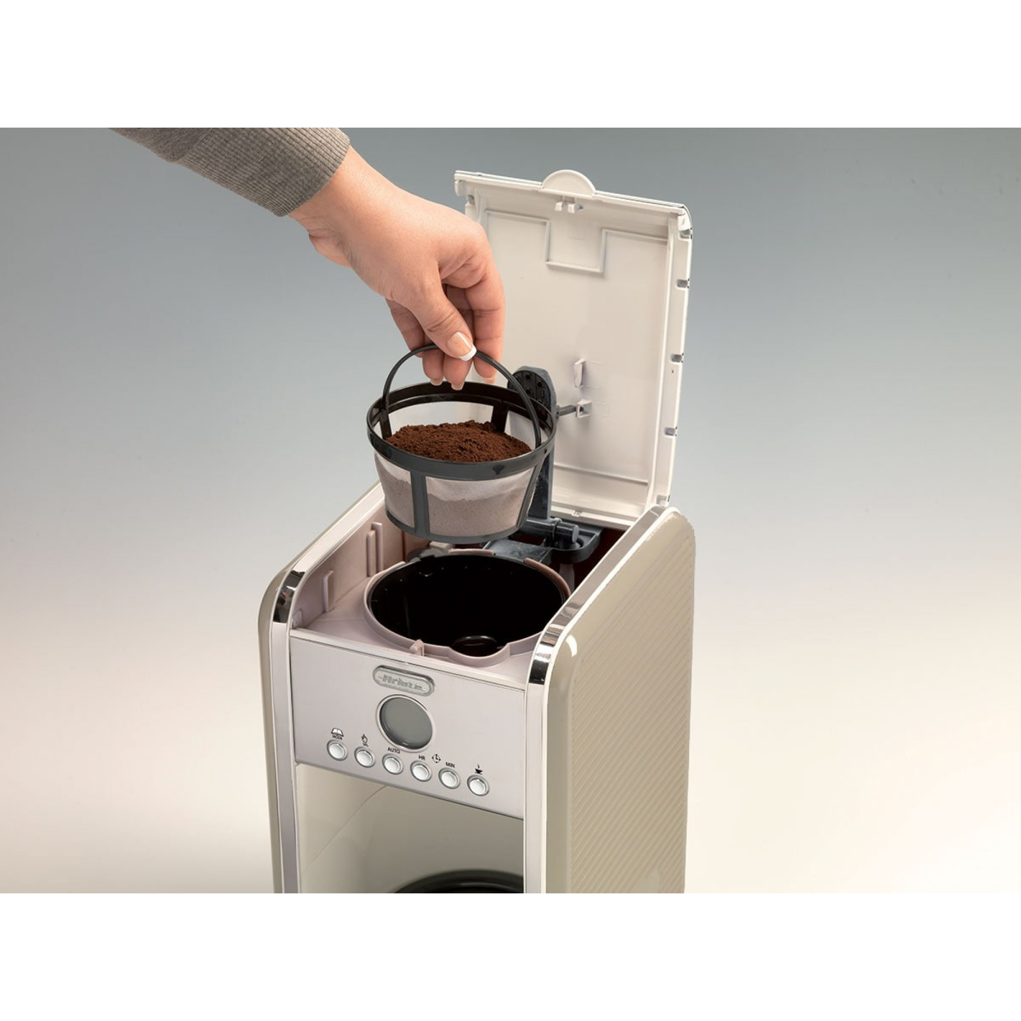 Person putting a filter with coffee grounds into a coffee maker.