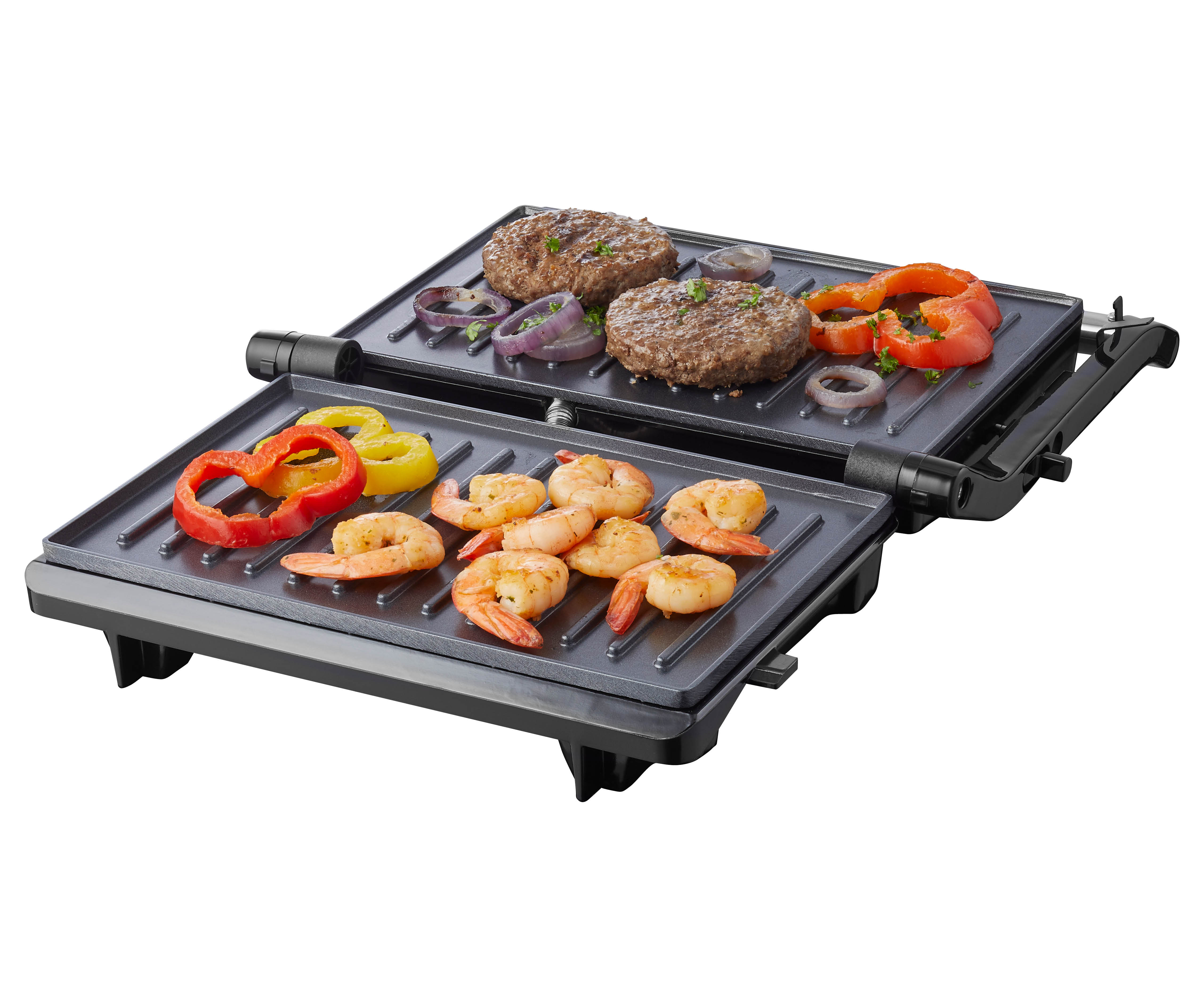Un grill ouvert avec des hamburgers, des crevettes et des légumes. Fond blanc, le grill est légèrement incliné.
