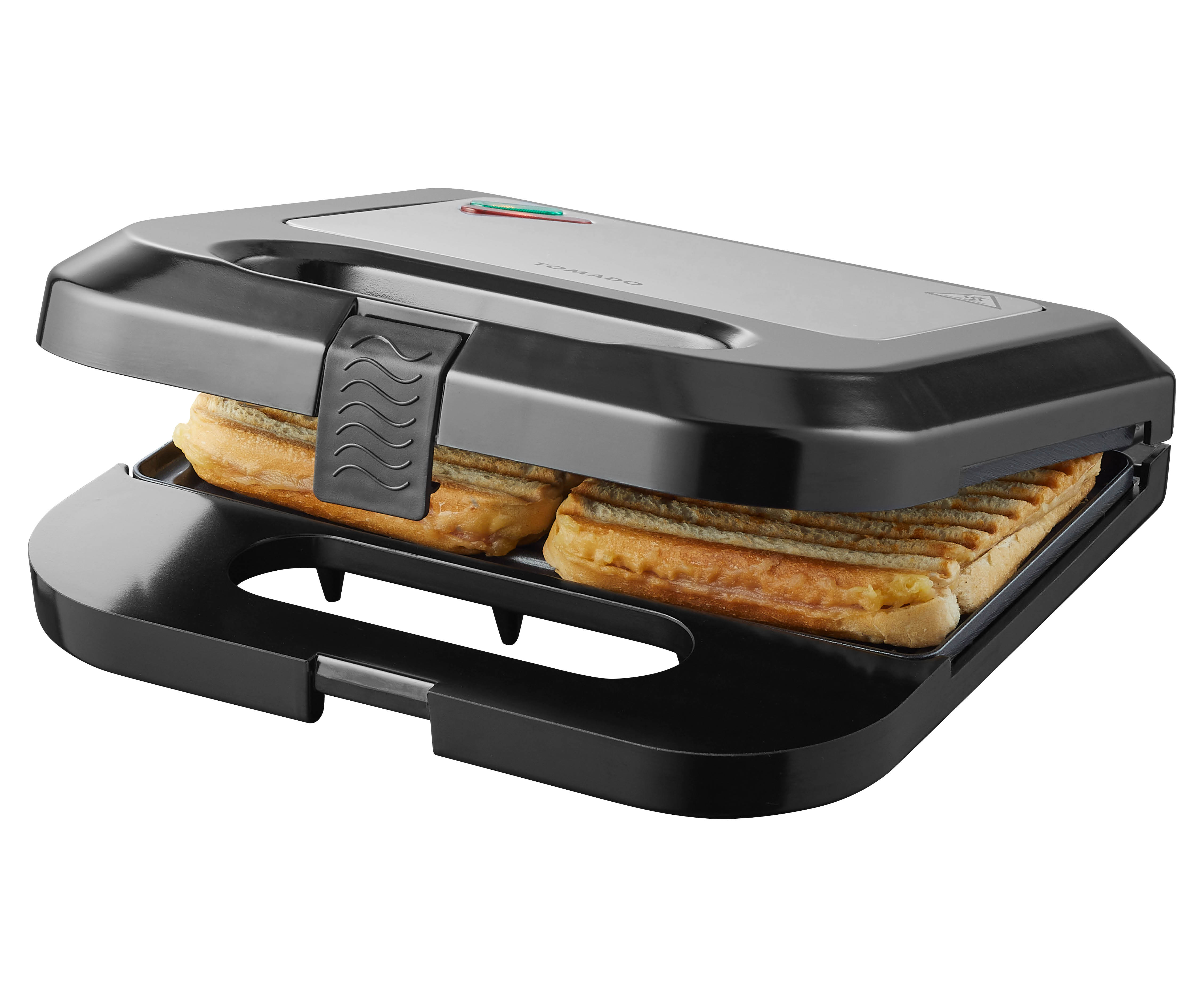 A closed black sandwich maker with sandwiches inside. The top is silver with a green power light.