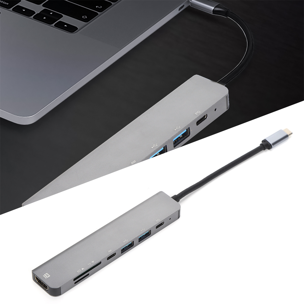 Ein silberner USB-C-Hub, der mit einem Laptop verbunden ist. Er hat mehrere Anschlüsse.