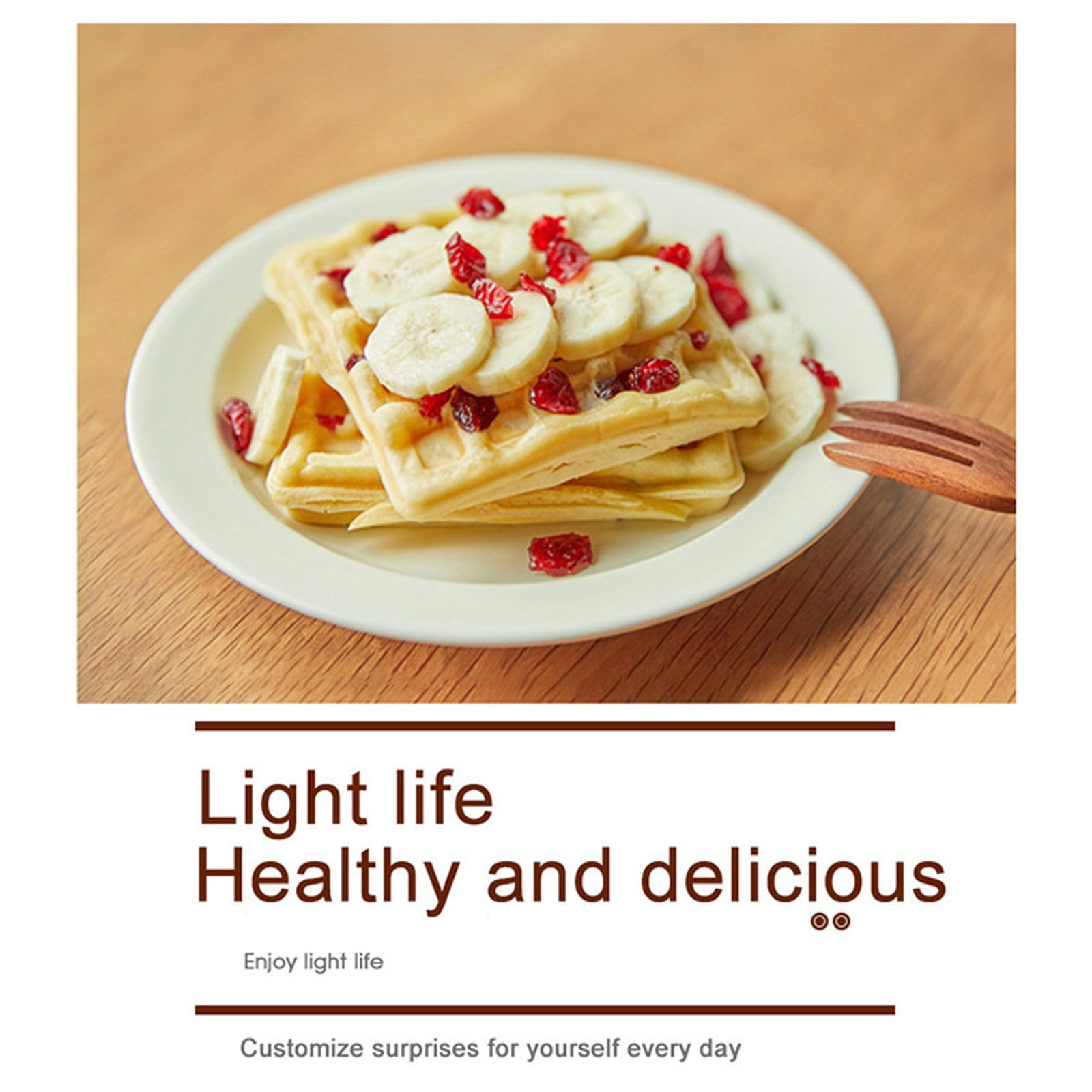 Waffeln mit Bananenscheiben und Cranberries auf einem weißen Teller mit einer Holzgabel.