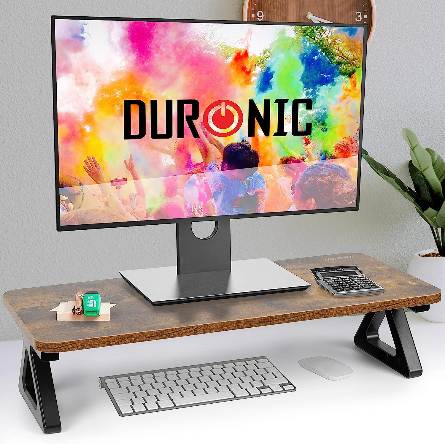 Schreibtisch mit Monitor, der ein farbenfrohes Bild zeigt, Tastatur, Maus und anderen Utensilien.