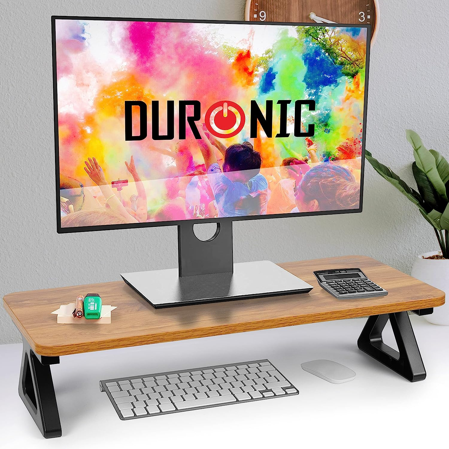 Ein Monitor auf einem Holzschreibtisch mit Tastatur und Maus, mit einem farbenfrohen Hintergrund.