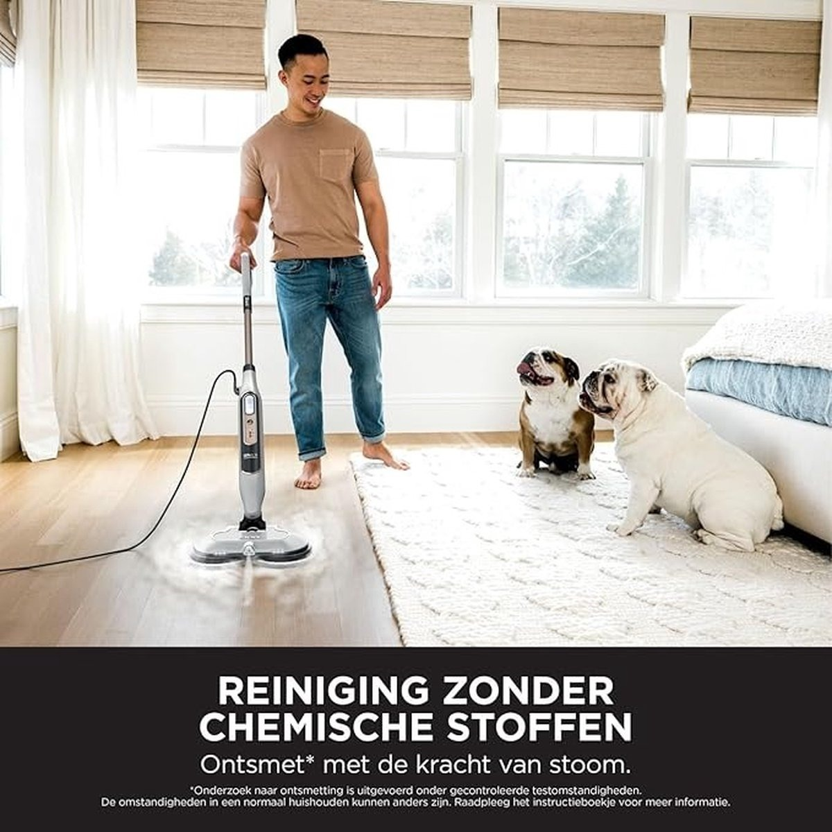 Ein Mann benutzt einen Dampfreiniger mit zwei Hunden im Hintergrund.