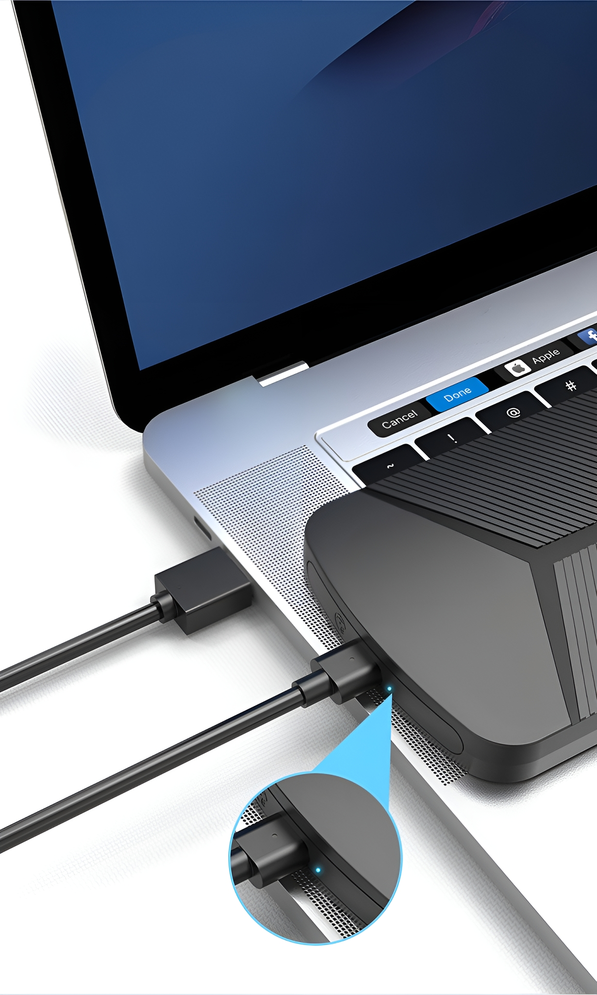 Ein Laptop ist mit einem schwarzen Gerät verbunden. Ein blaues Licht leuchtet auf dem Gerät.