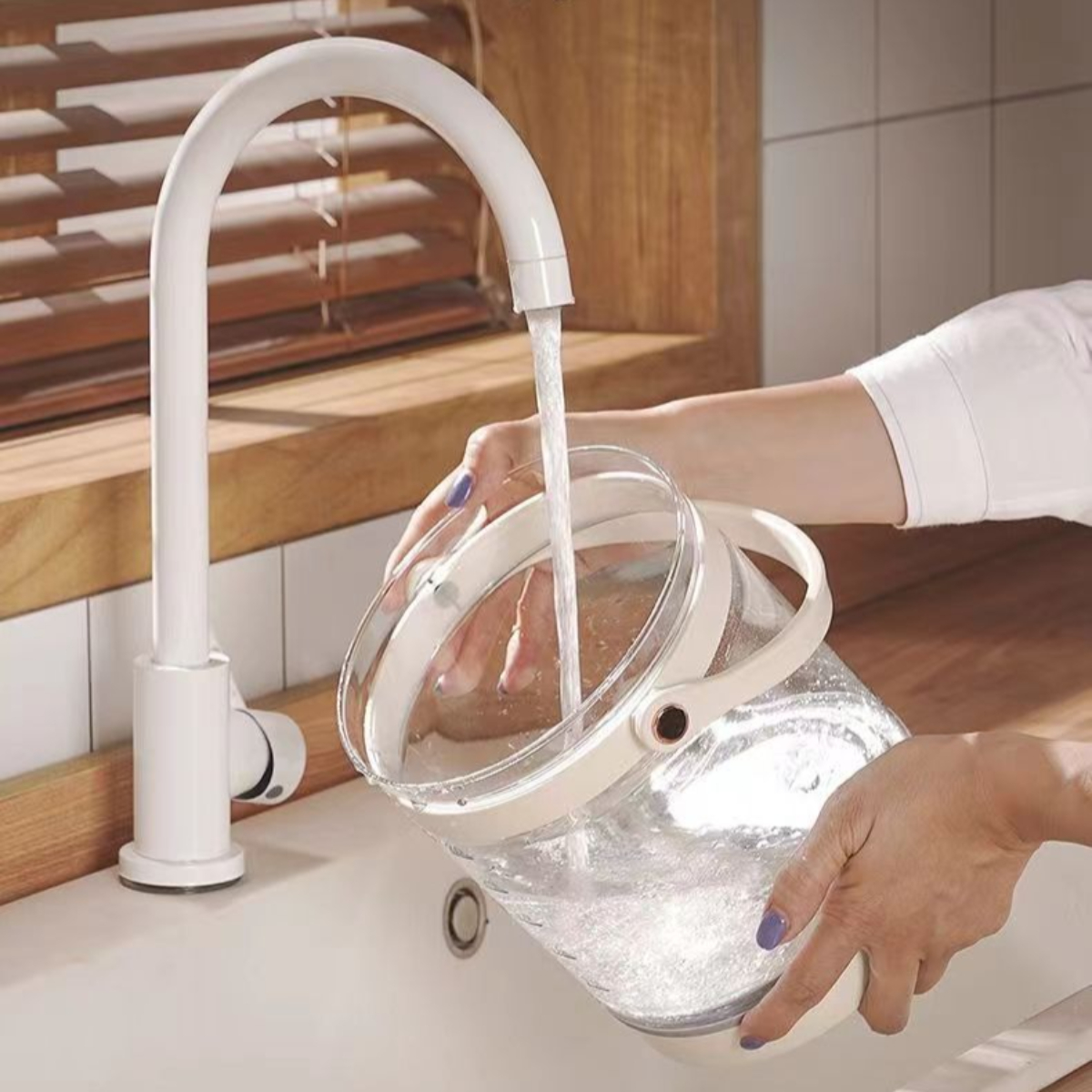 Wasser wird aus einem weißen Wasserhahn in einen transparenten Eimer gegossen.