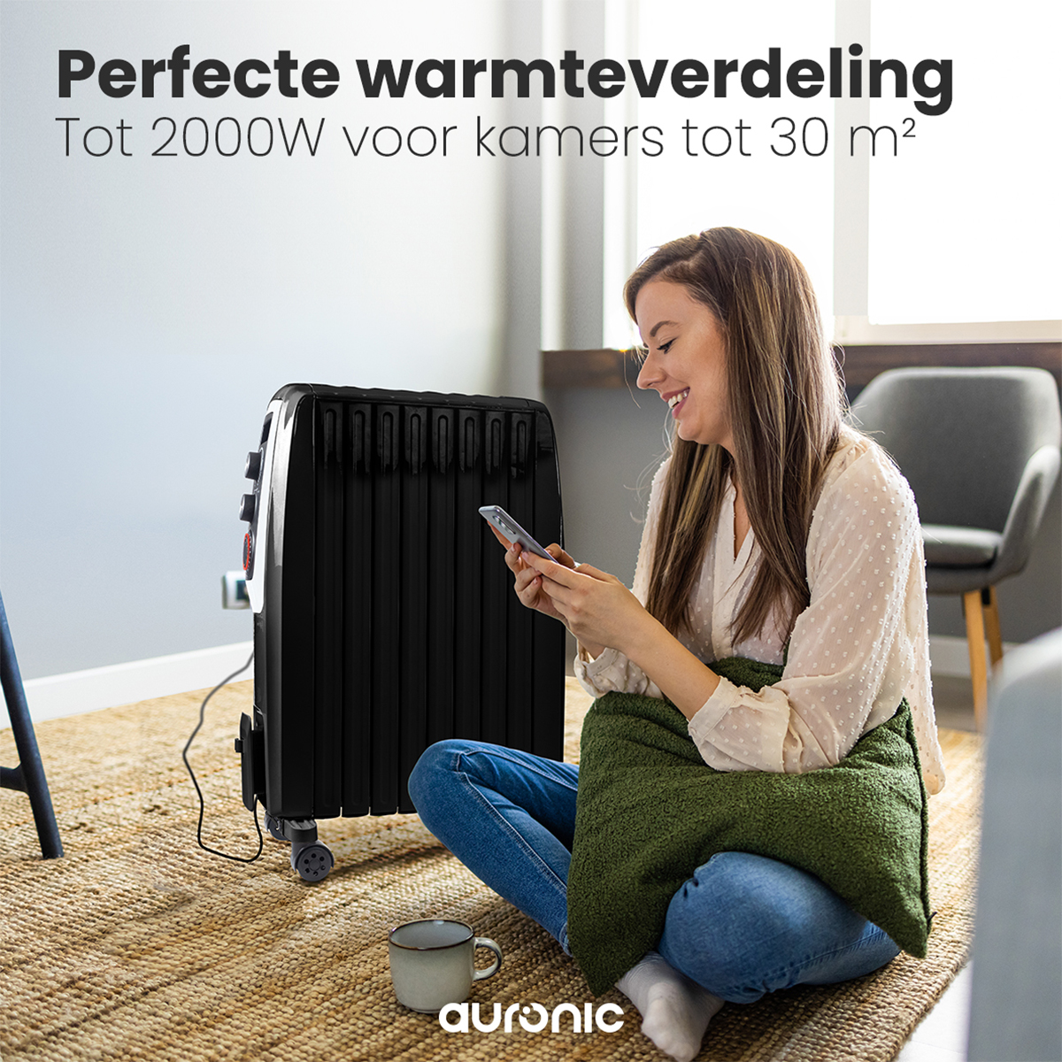 Vrouw zit bij een zwarte kachel. Ze kijkt naar haar telefoon. Achtergrond is een kamer.