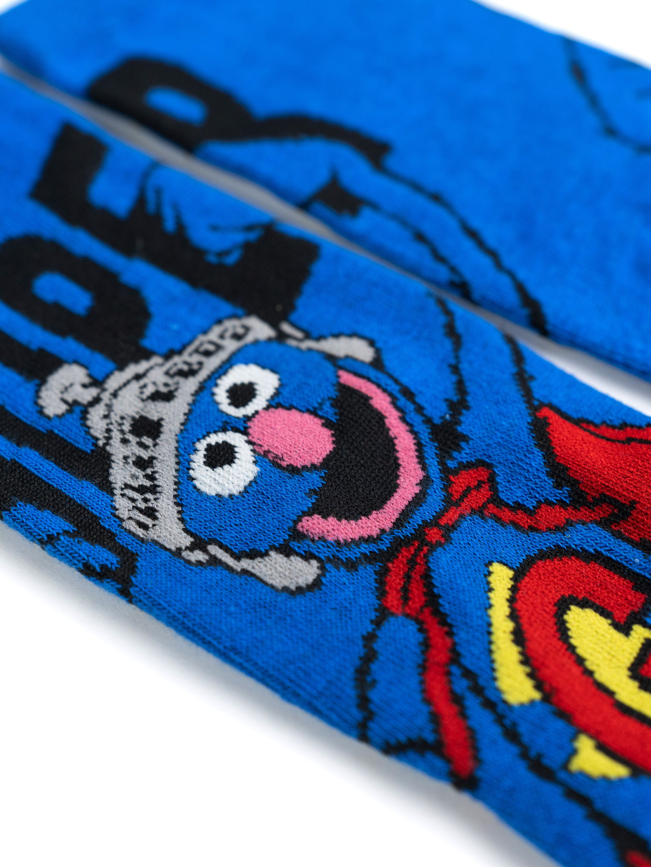 Blaue Socken mit Grover aus der Sesamstraße. Mit rosa Mund, blauem Fell und roten Details.