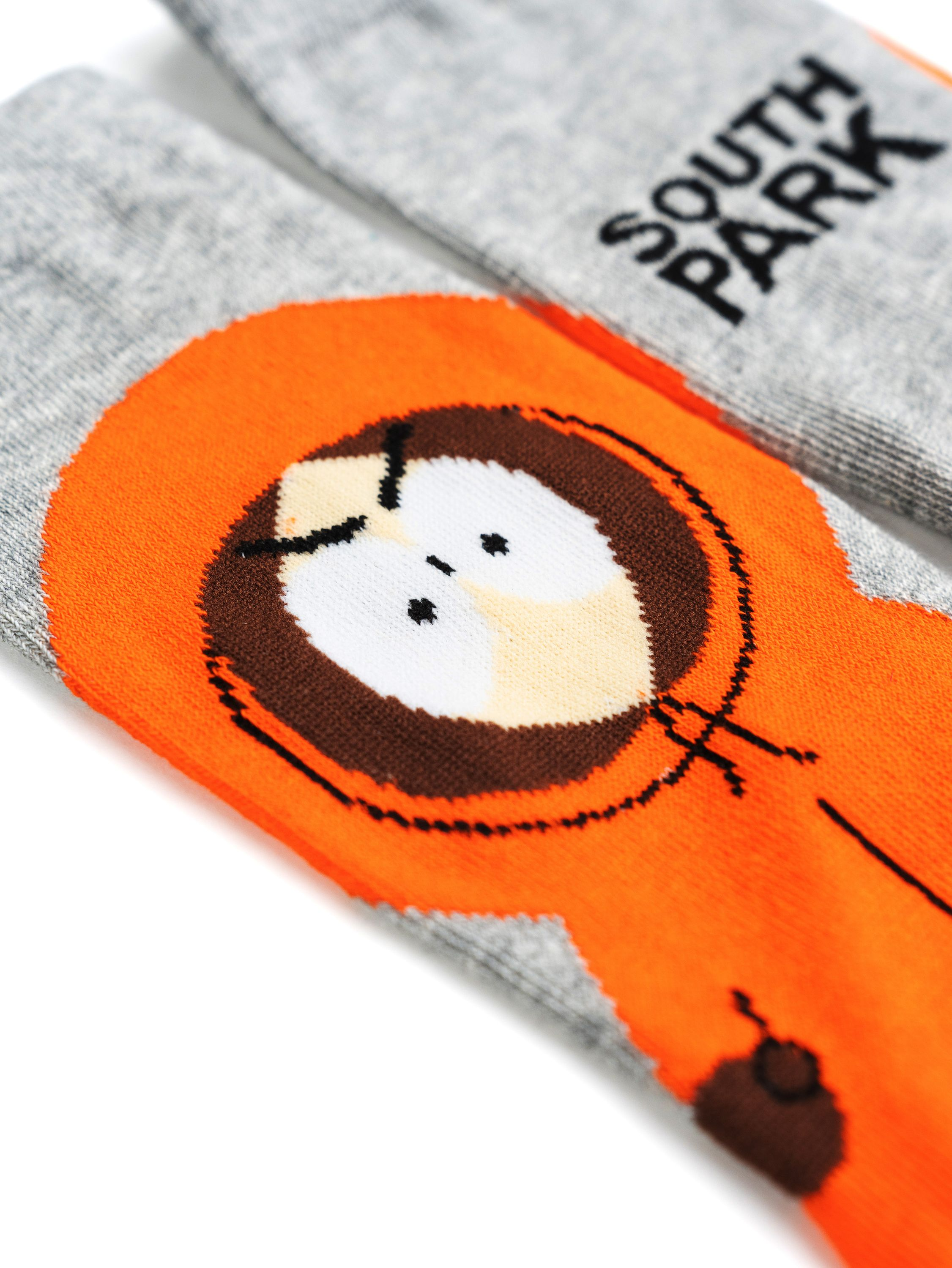 Nahaufnahme von South Park Socken. Eine Socke zeigt Kennys Gesicht in Orange, die andere das South Park Logo.