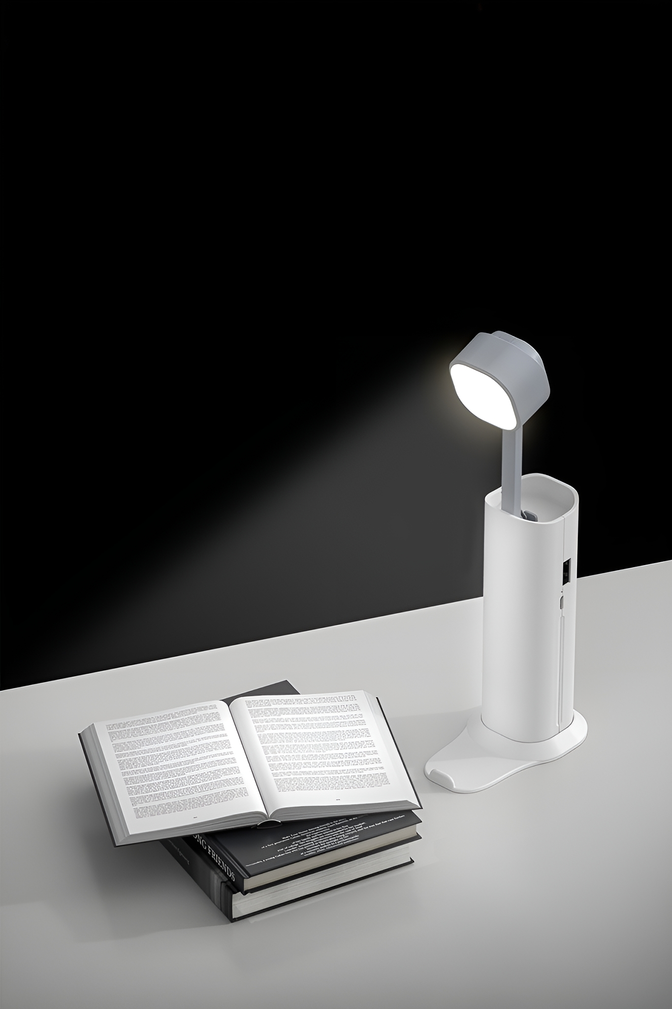Schreibtischlampe mit offenem Buch und gestapelten Büchern. Weiße Lampe, schwarz-weißer Hintergrund.
