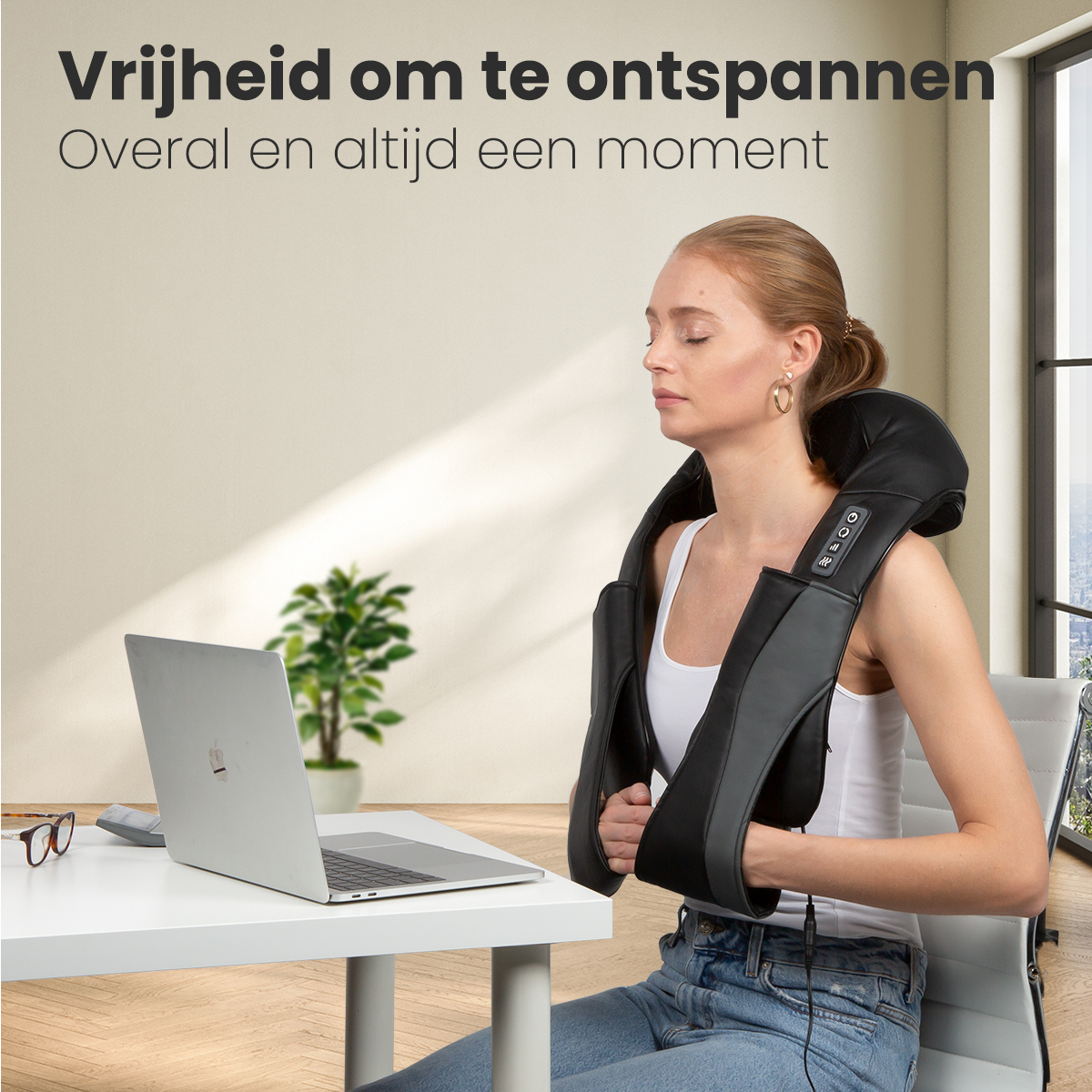 Woman using a laptop with a neck massager on. Desk has a keyboard and glasses.