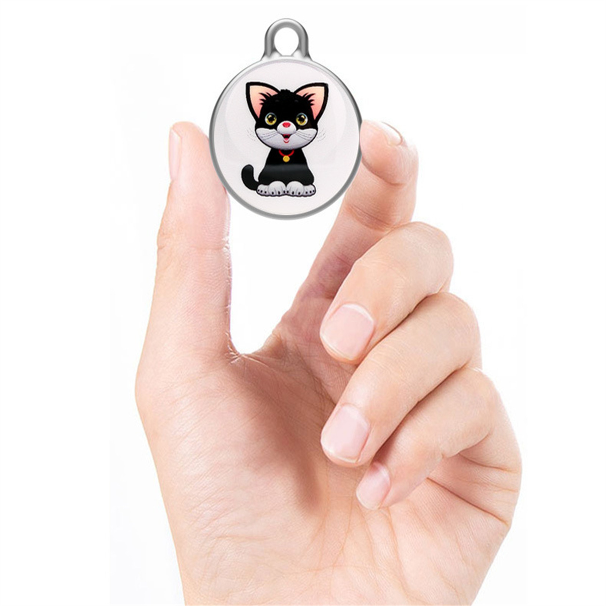 Eine Hand, die einen runden Haustieranhänger mit einer Cartoon-Katze hält. Die Katze ist schwarz und weiß.