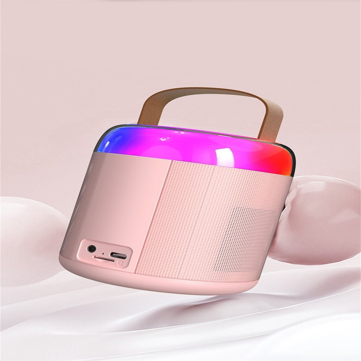 Ein rosa tragbarer Lautsprecher mit Griff, mit bunten Lichtern und neutralem Hintergrund.