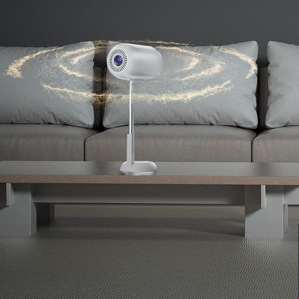 Ein weißer Projektor auf einem Ständer, der Licht auf ein hellgraues Sofa projiziert. Der Hintergrund ist unscharf.