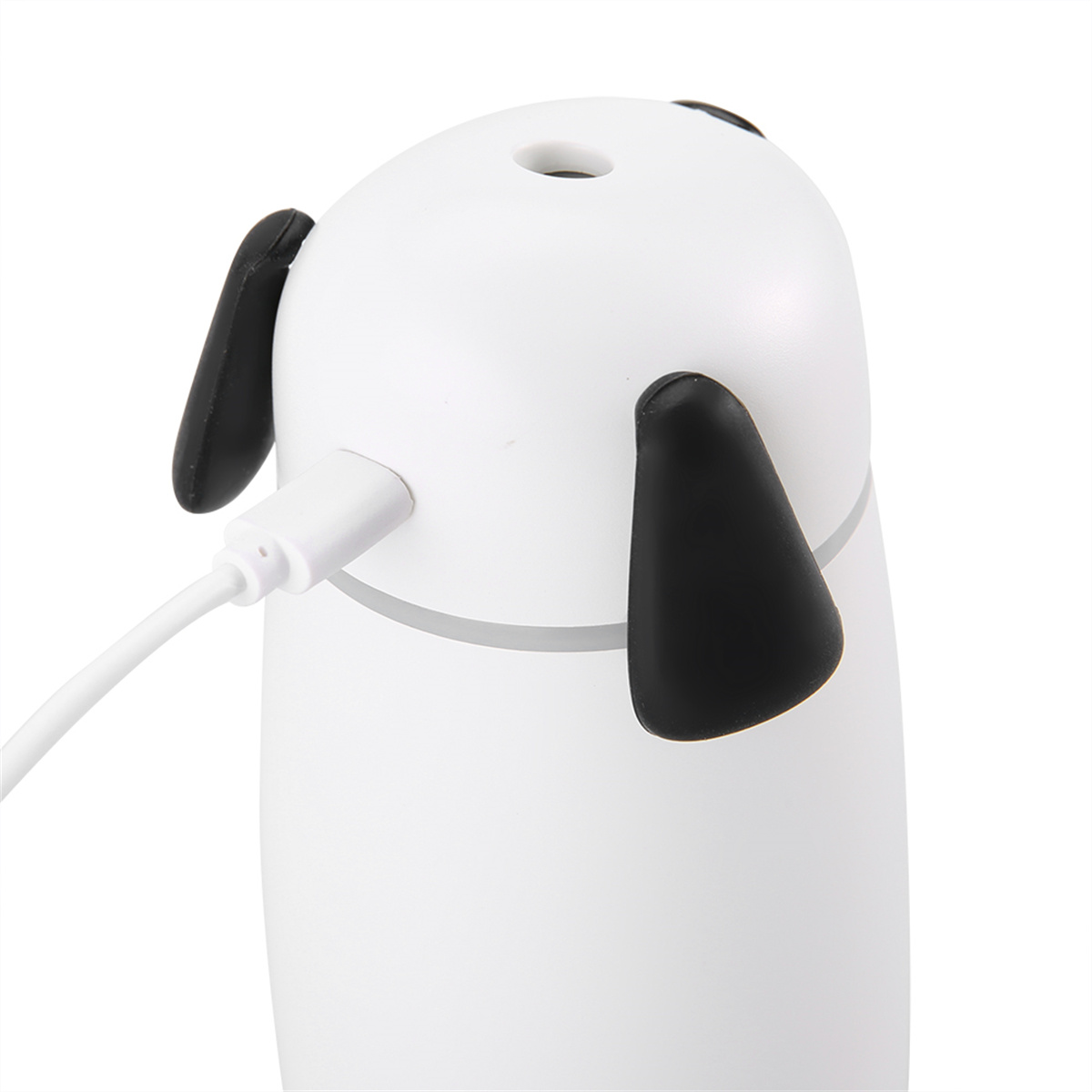 Ein weißer, hundeförmiger Luftbefeuchter mit schwarzen Ohren. Ein weißes Ladekabel ist an der Seite angeschlossen.