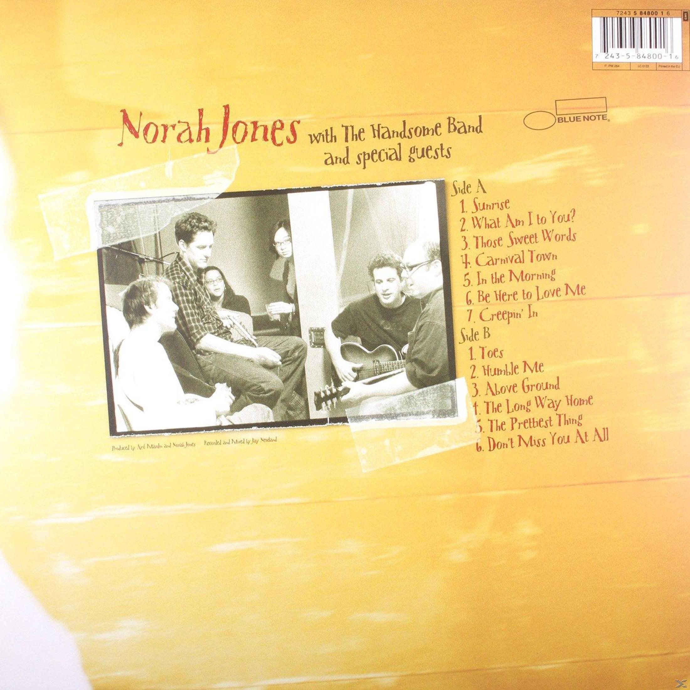 Retro album di Norah Jones con 'The Handsome Band'. Gruppo che suona strumenti. Sfondo giallo.