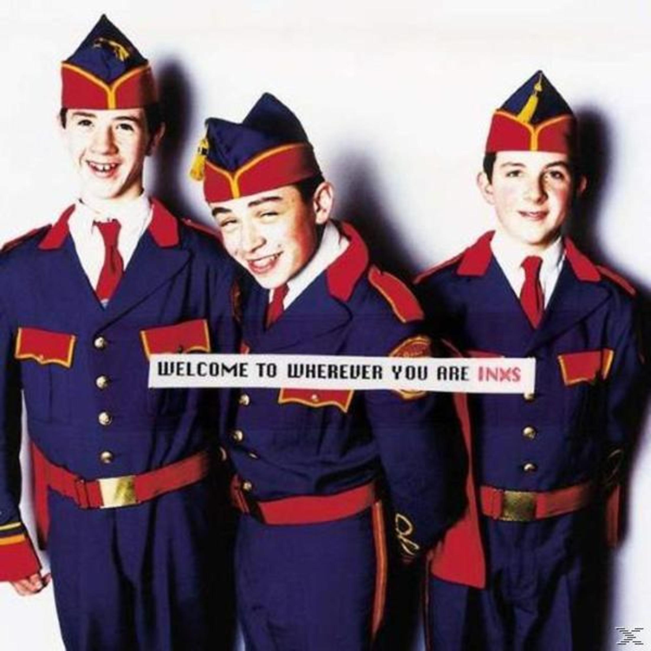 Albumhoes: Drie jonge mannen in uniformen in militaire stijl. Tekst: 'Welcome to Wherever You Are' INXS.