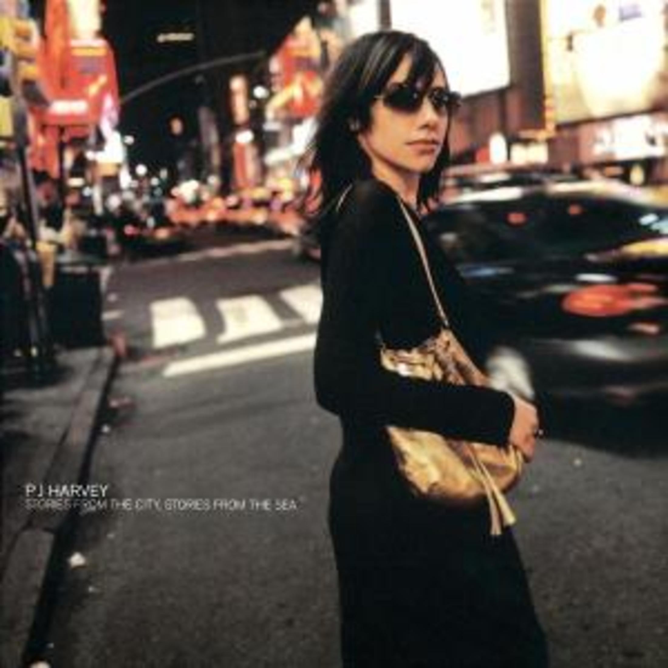 Albumhoes van PJ Harvey. Een vrouw in het zwart staat 's nachts op straat.
