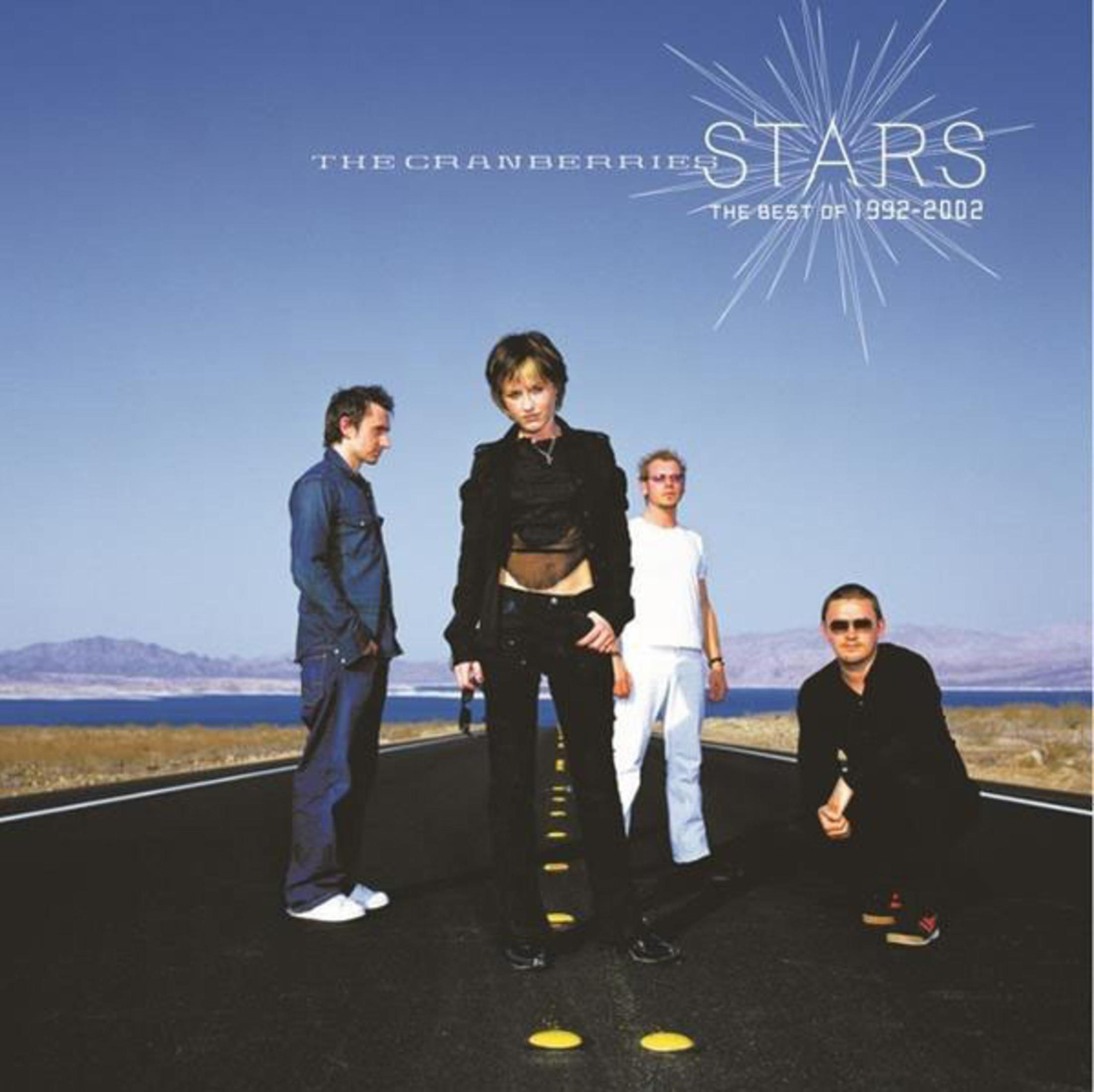 Pochette de l'album avec The Cranberries. Le groupe se tient sur une route, avec le texte : Stars, Best of 1992-2002.