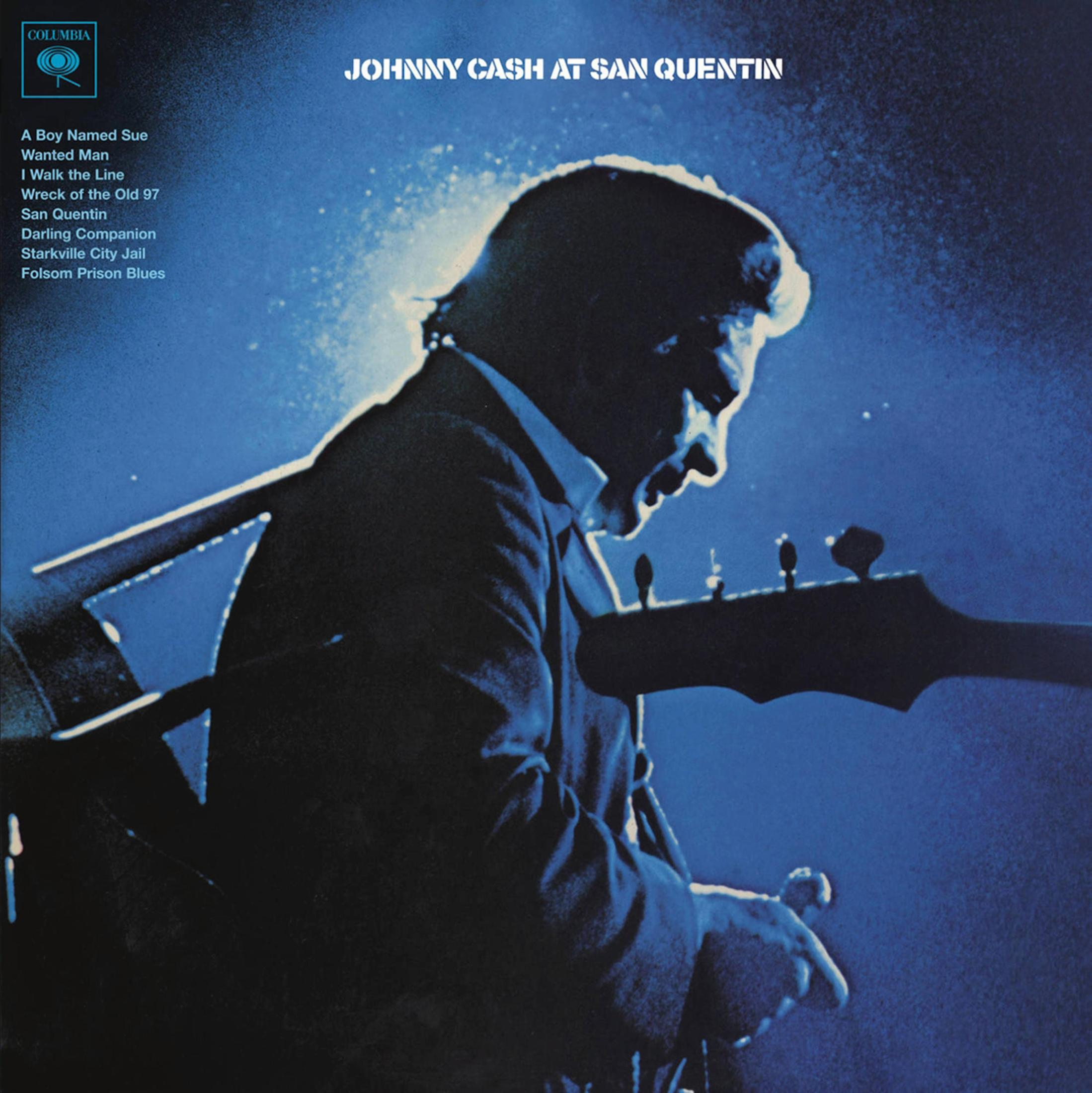 Pochette d'album de Johnny Cash, de profil, jouant de la guitare sur scène avec un éclairage bleu.