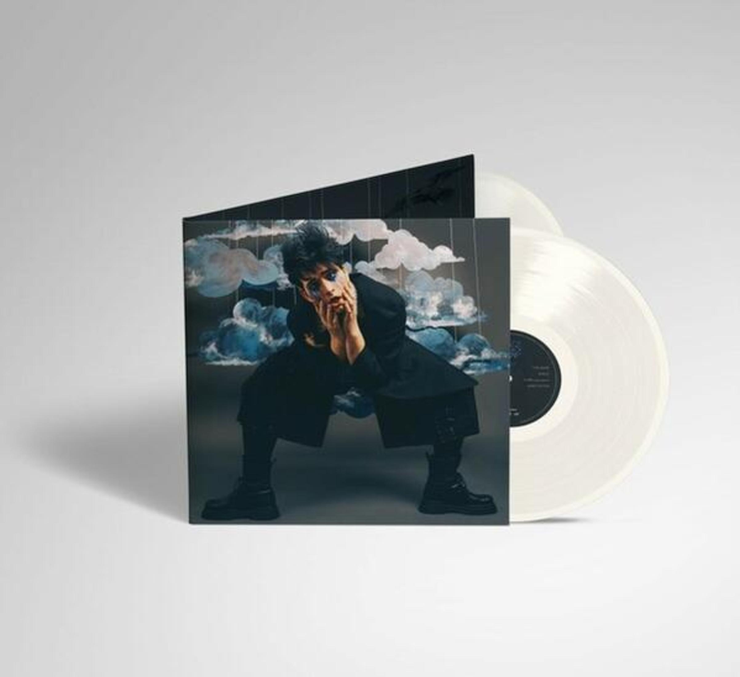 Copertina dell'album con persona in abito nero, disco in vinile bianco accanto, nuvole.