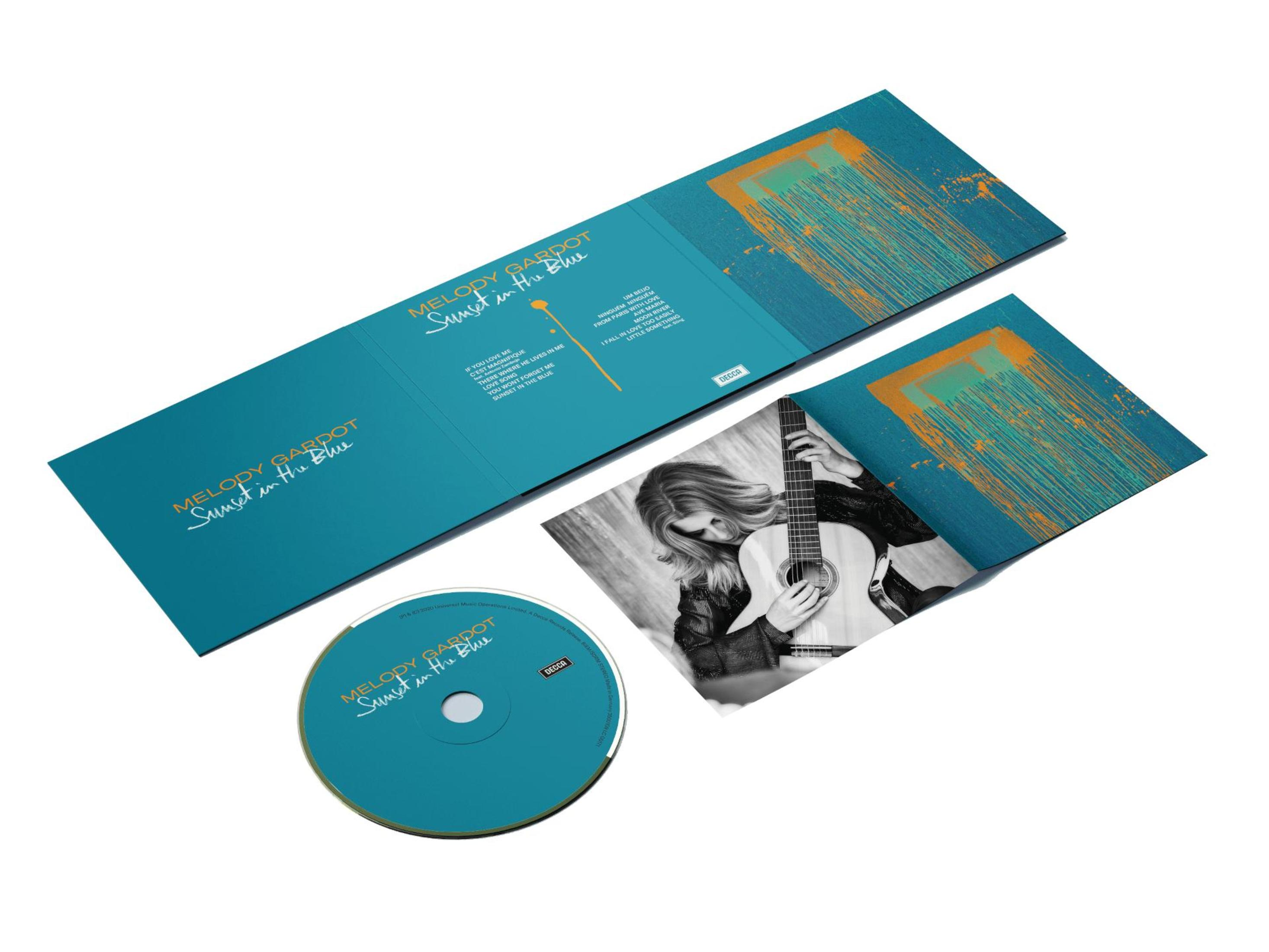 Custodia del CD aperta, con CD e inserto che mostra una donna con una chitarra. Testo: 'Sunset in the Blue'.