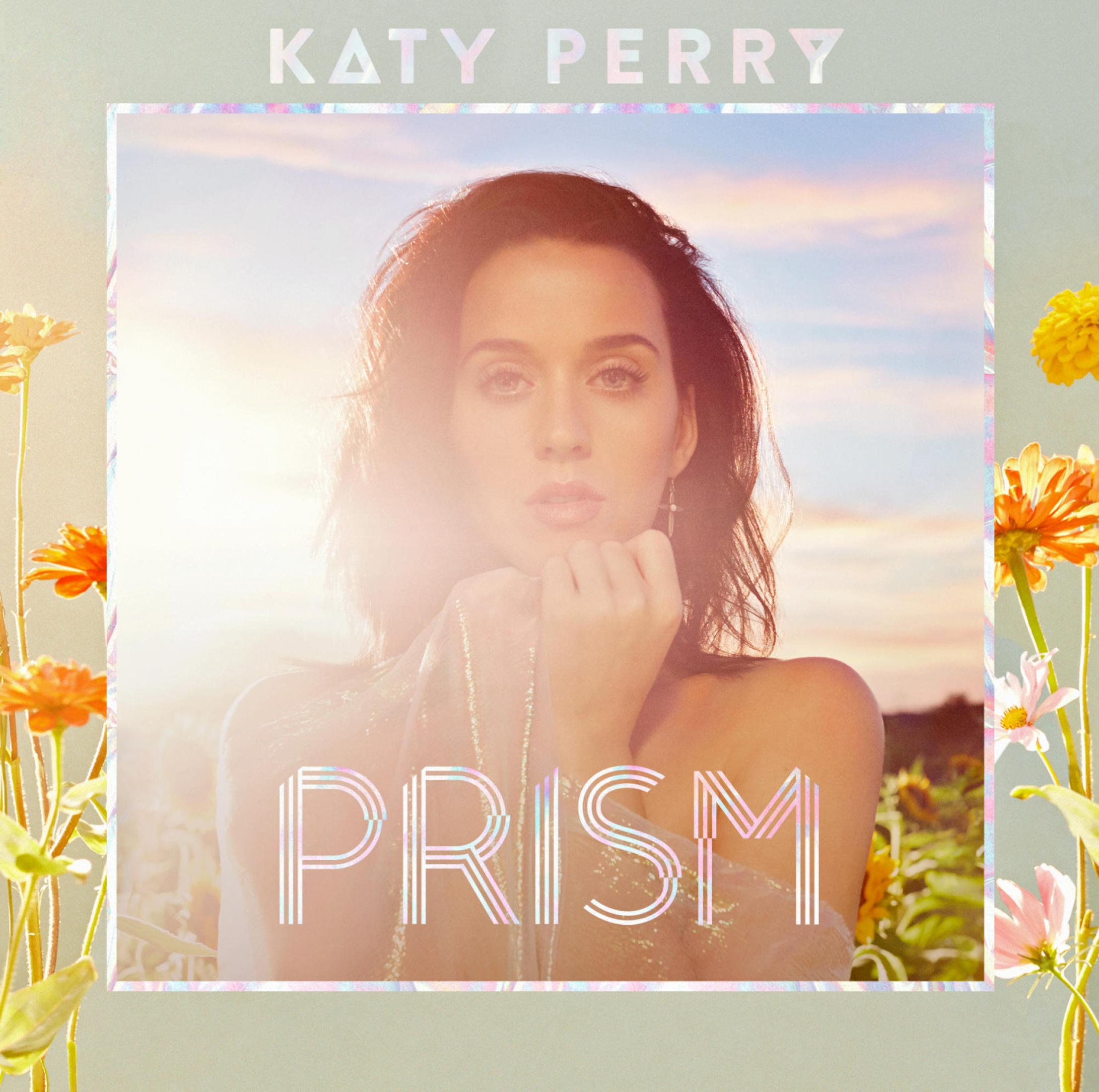 Pochette d'album, Katy Perry, dans une robe semi-transparente, entourée de fleurs, avec le texte "PRISM".