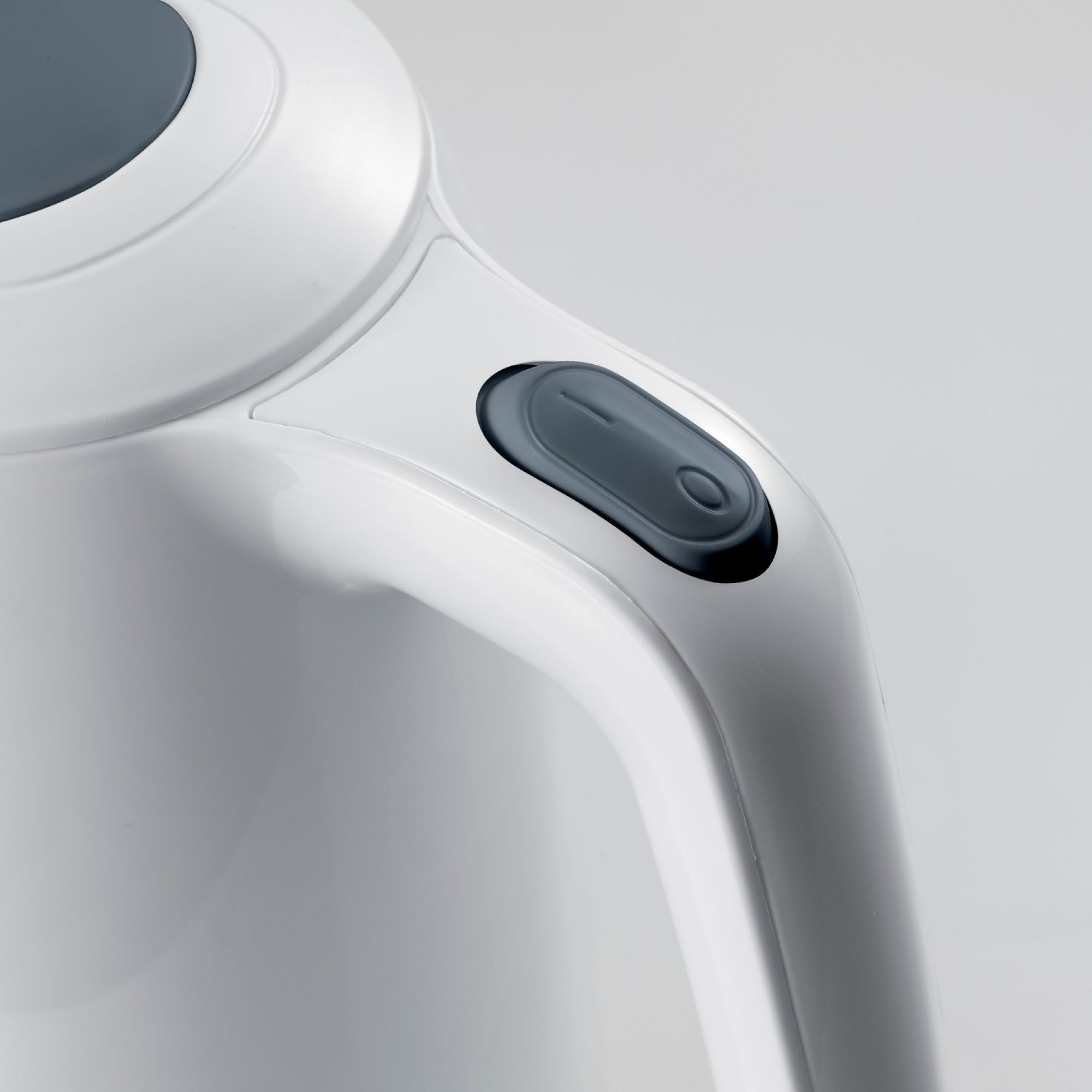 Primo piano di un bollitore elettrico bianco con un pulsante grigio scuro.