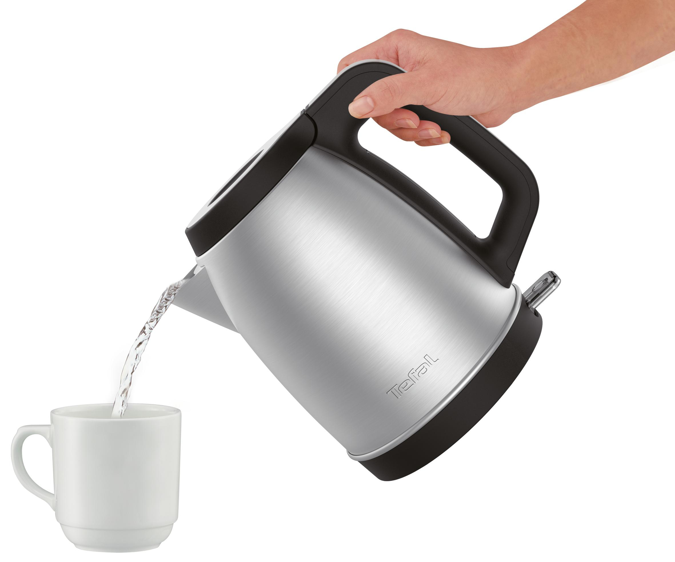 Srebrny czajnik nalewa wodę do białego kubka. Ręka trzyma czajnik. Izolowany na białym tle.