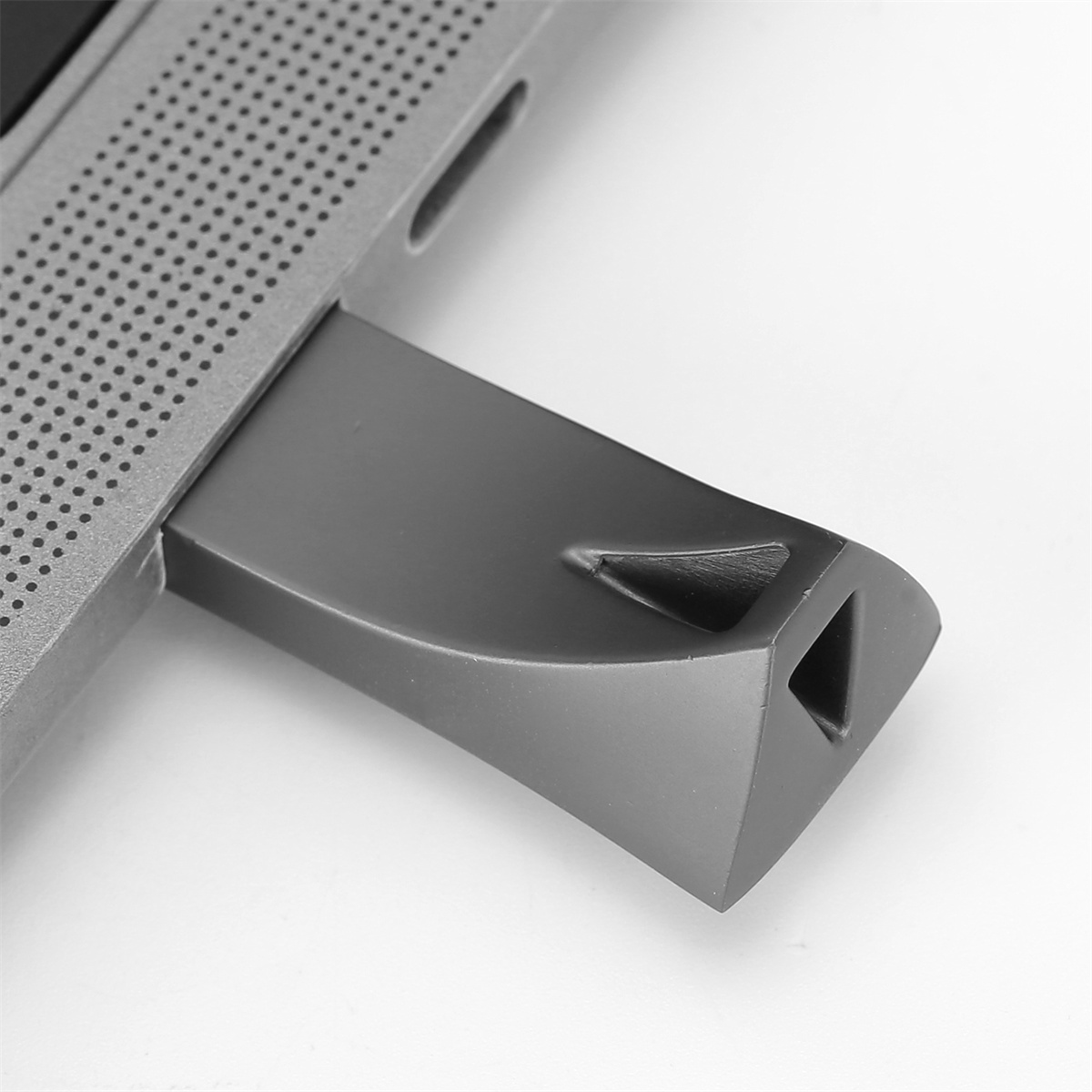 Grauer USB-C-Adapter, der in ein Gerät eingesteckt ist. Der Adapter hat ein dreieckiges Ende.