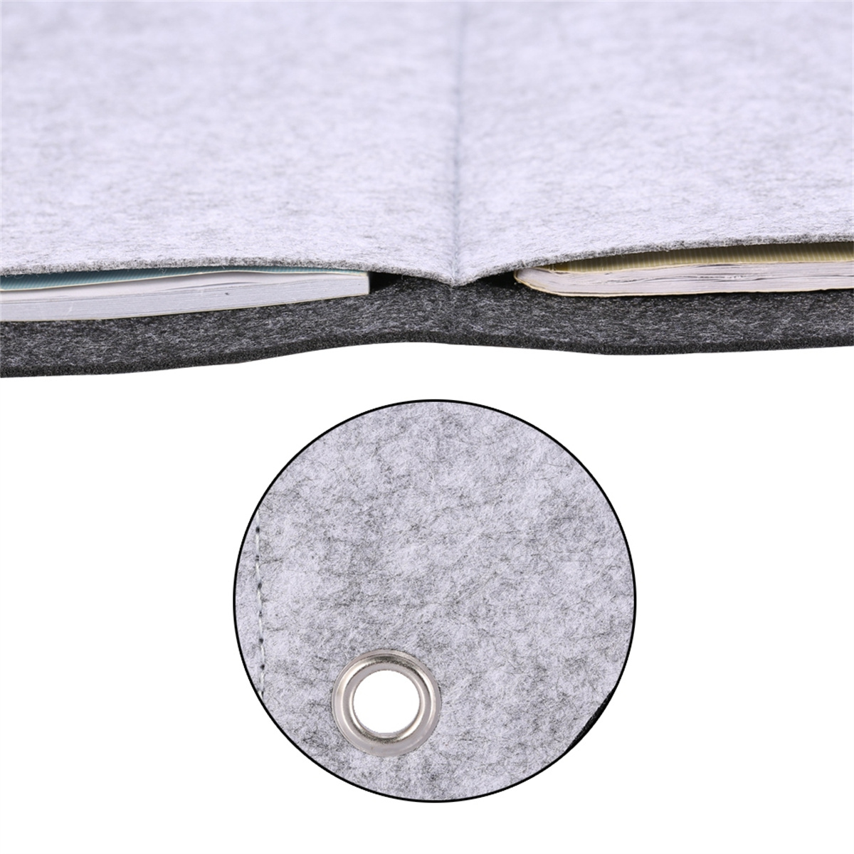 Nahaufnahme von grauem Filz mit Notizbuch und Loch mit Metallring.