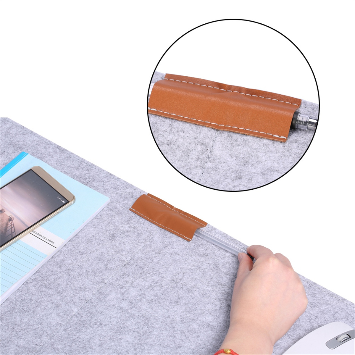 Eine Hand hält einen Stift in der Nähe eines Filz-Pads mit Stifthalter.