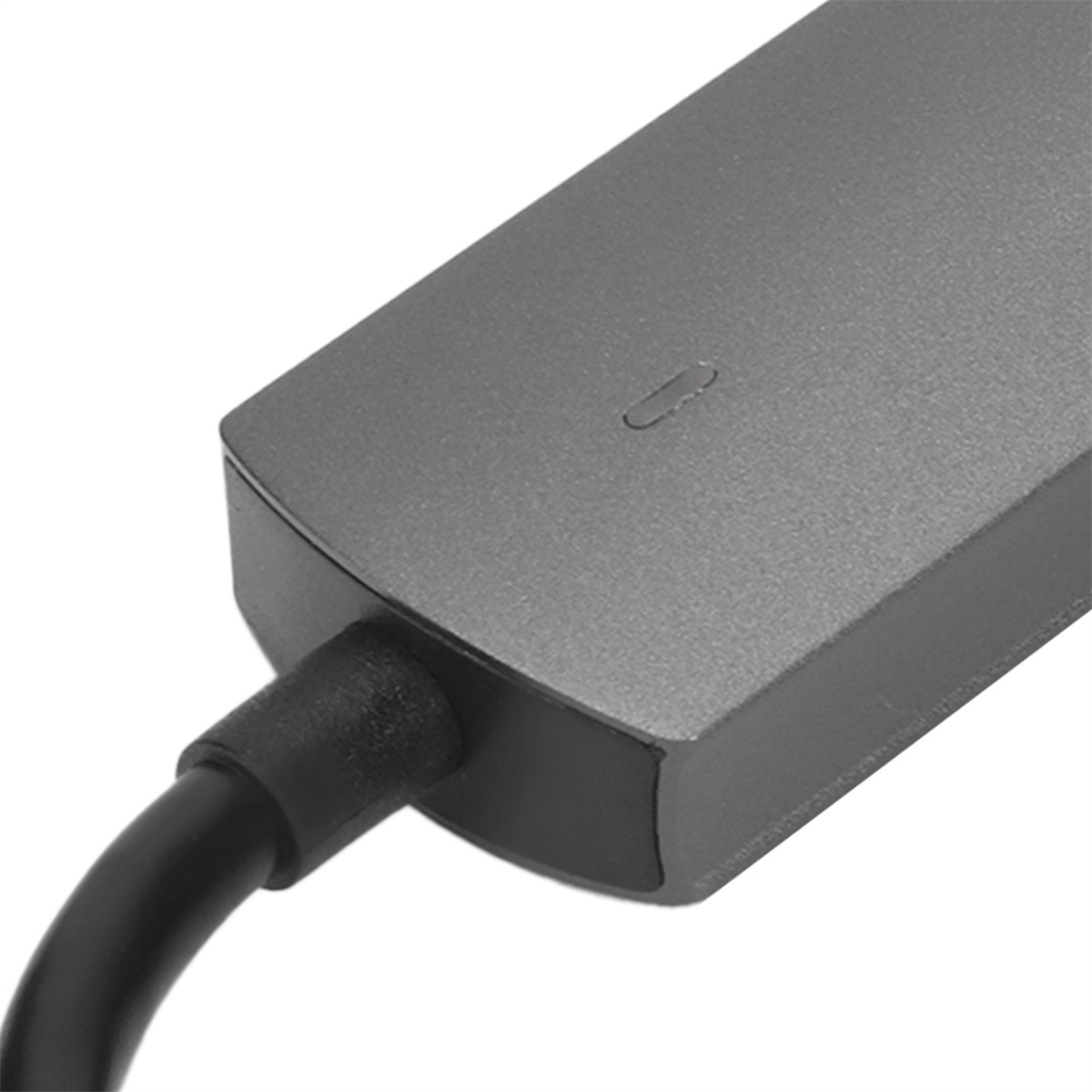 Ein grauer Adapter mit angeschlossenem schwarzen Kabel, Nahaufnahme.