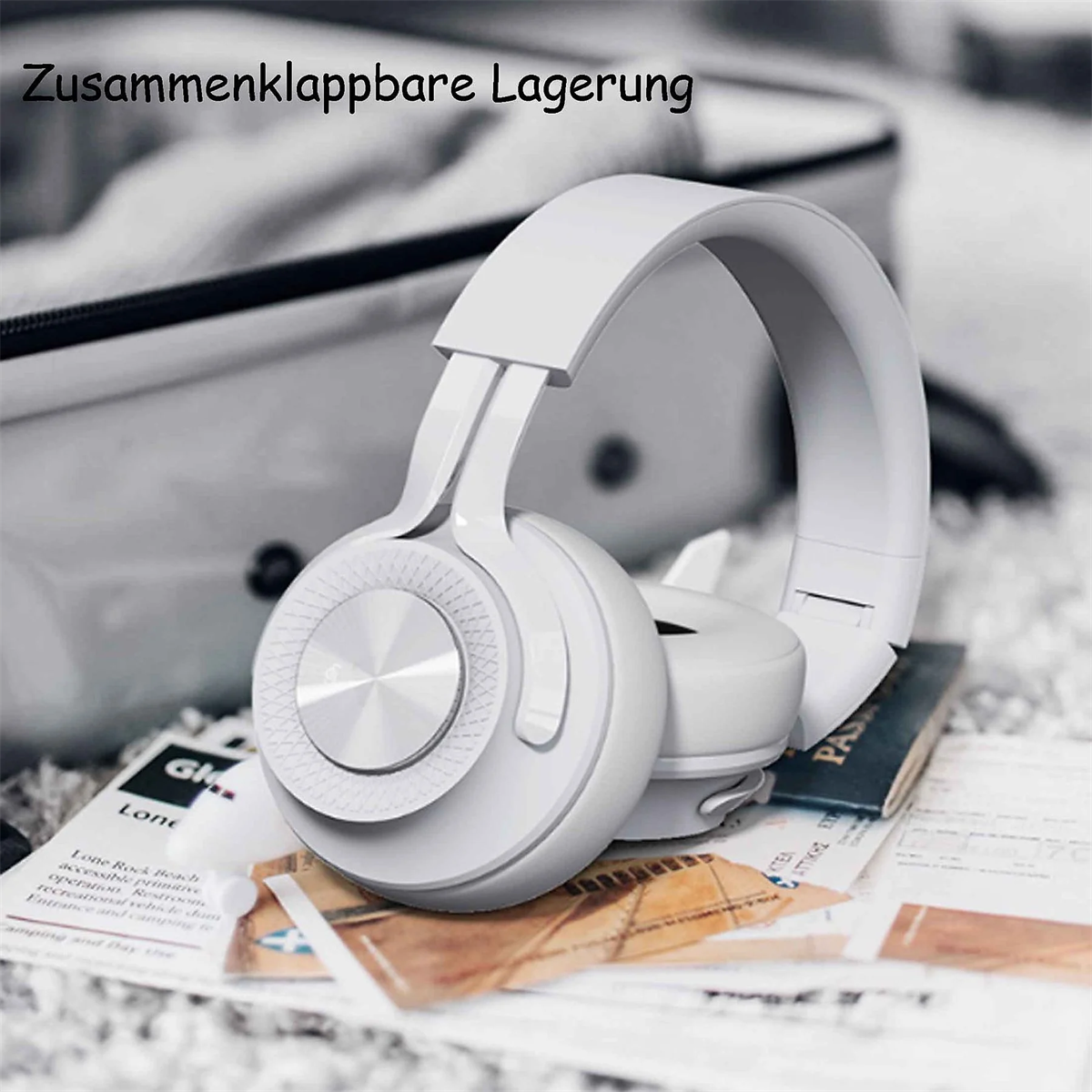 Weiße Kopfhörer auf einer Oberfläche, mit Reisetasche im Hintergrund und Reisedokumenten.