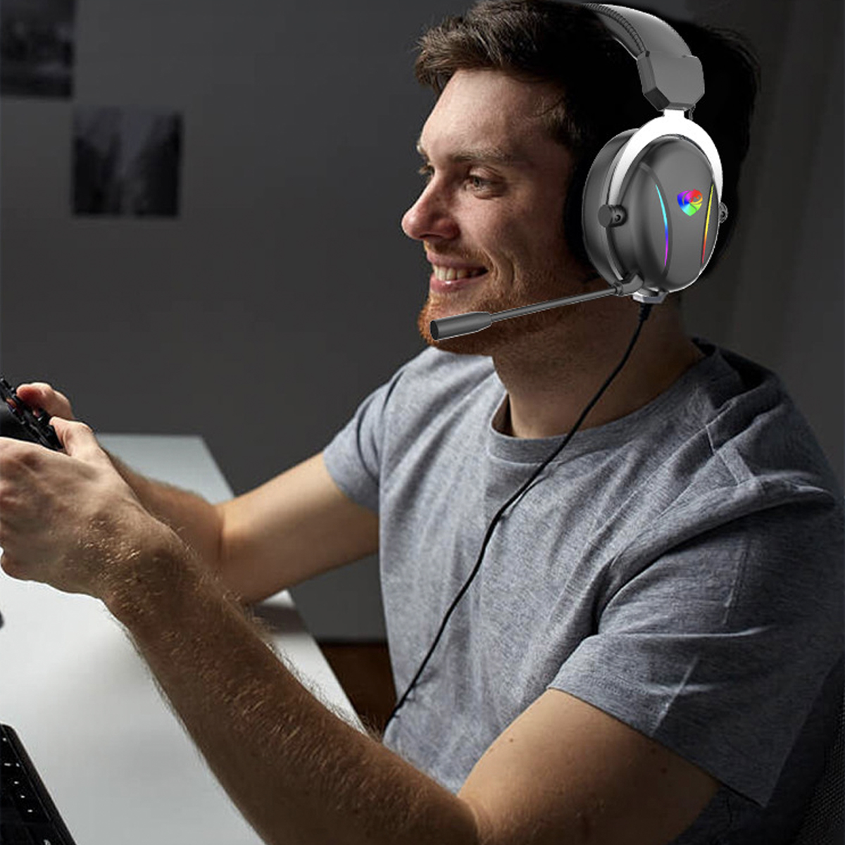 Ein Mann mit Headset lächelt, während er ein Spiel spielt. Er hält einen Controller.