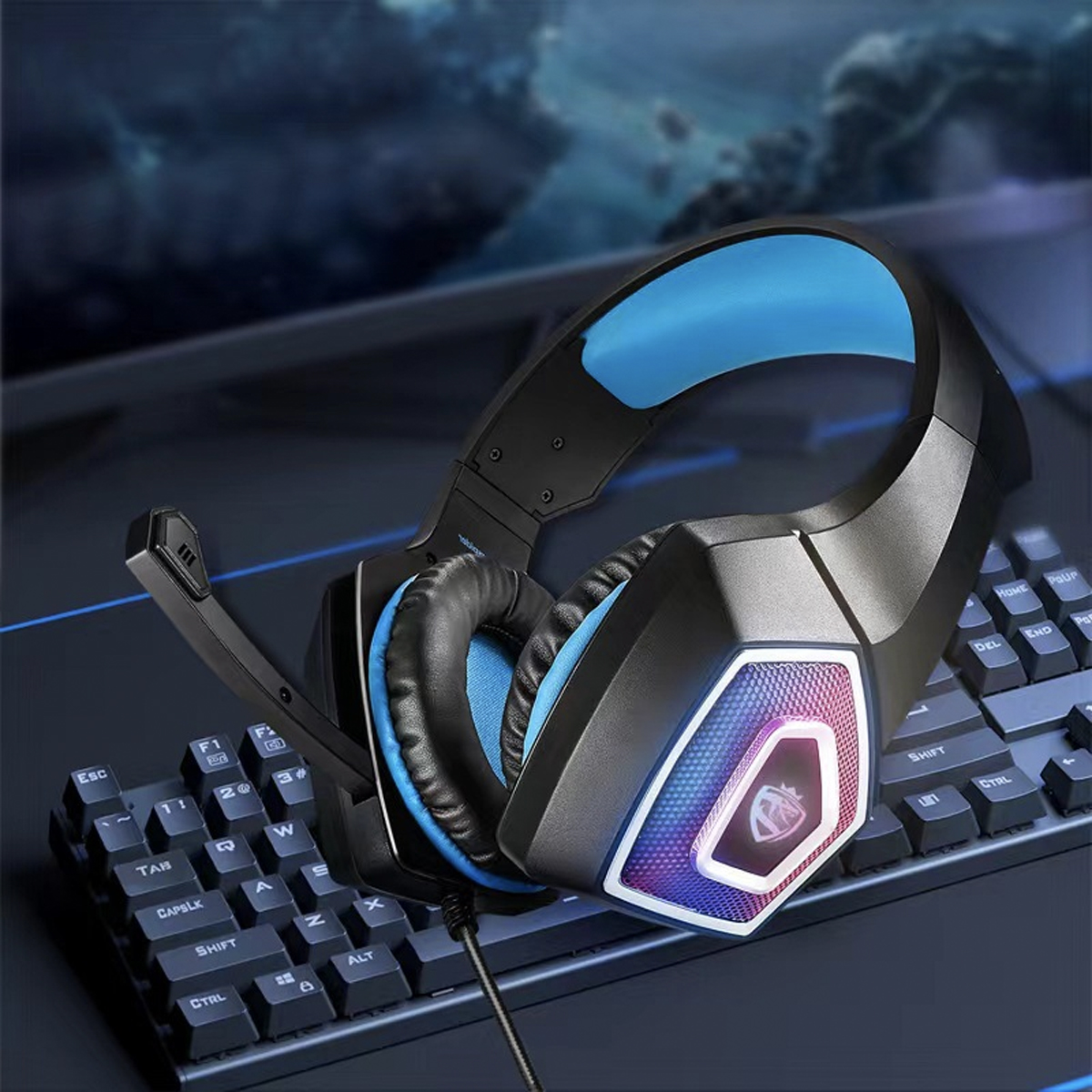 Schwarzes und blaues Gaming-Headset auf der Tastatur. Es hat ein Mikrofon und beleuchtete Ohrmuscheln.