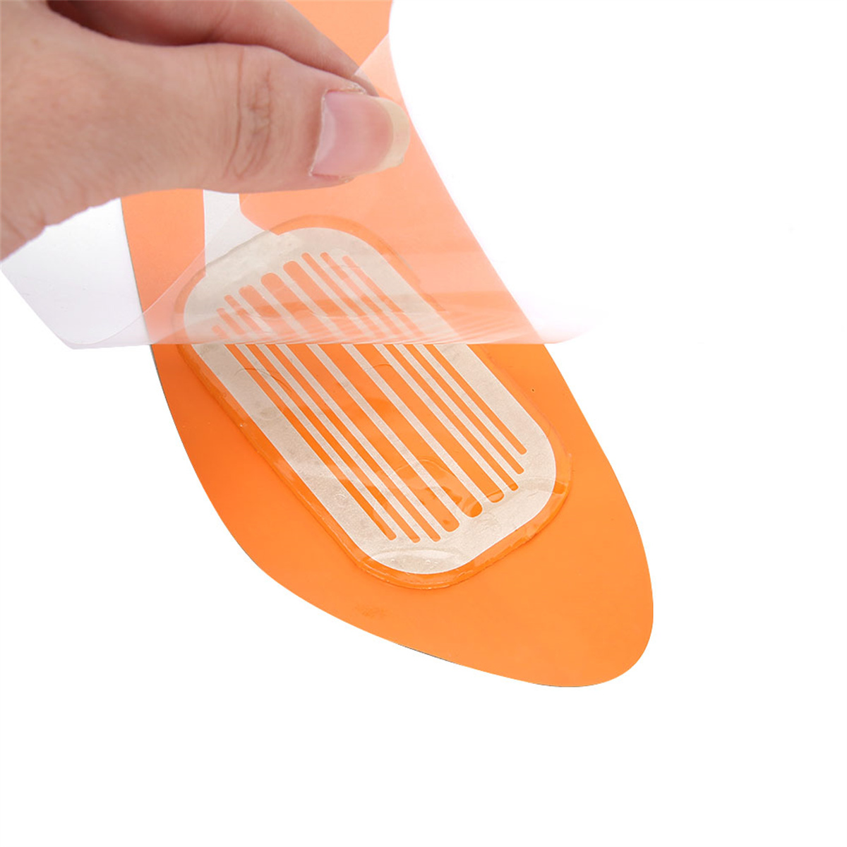 Eine Hand zieht eine Schutzfolie von einer orangefarbenen Einlegesohle ab und gibt einen weißen, gestreiften Klebebereich frei.