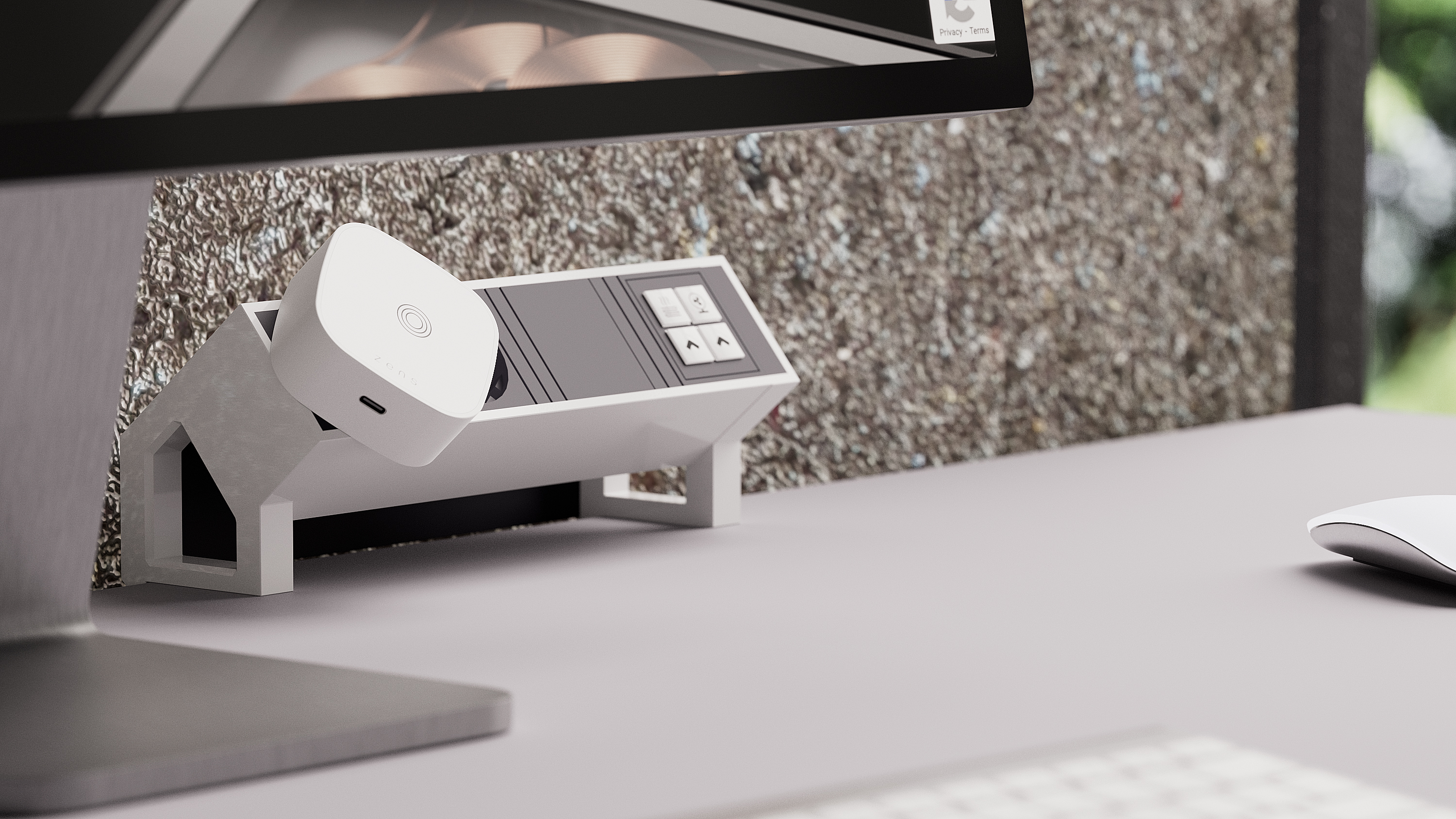 Ein Computermonitor und ein weißer Schreibtisch. Ein kleines weißes Gerät befindet sich auf einem Regal, das am Monitor befestigt ist.